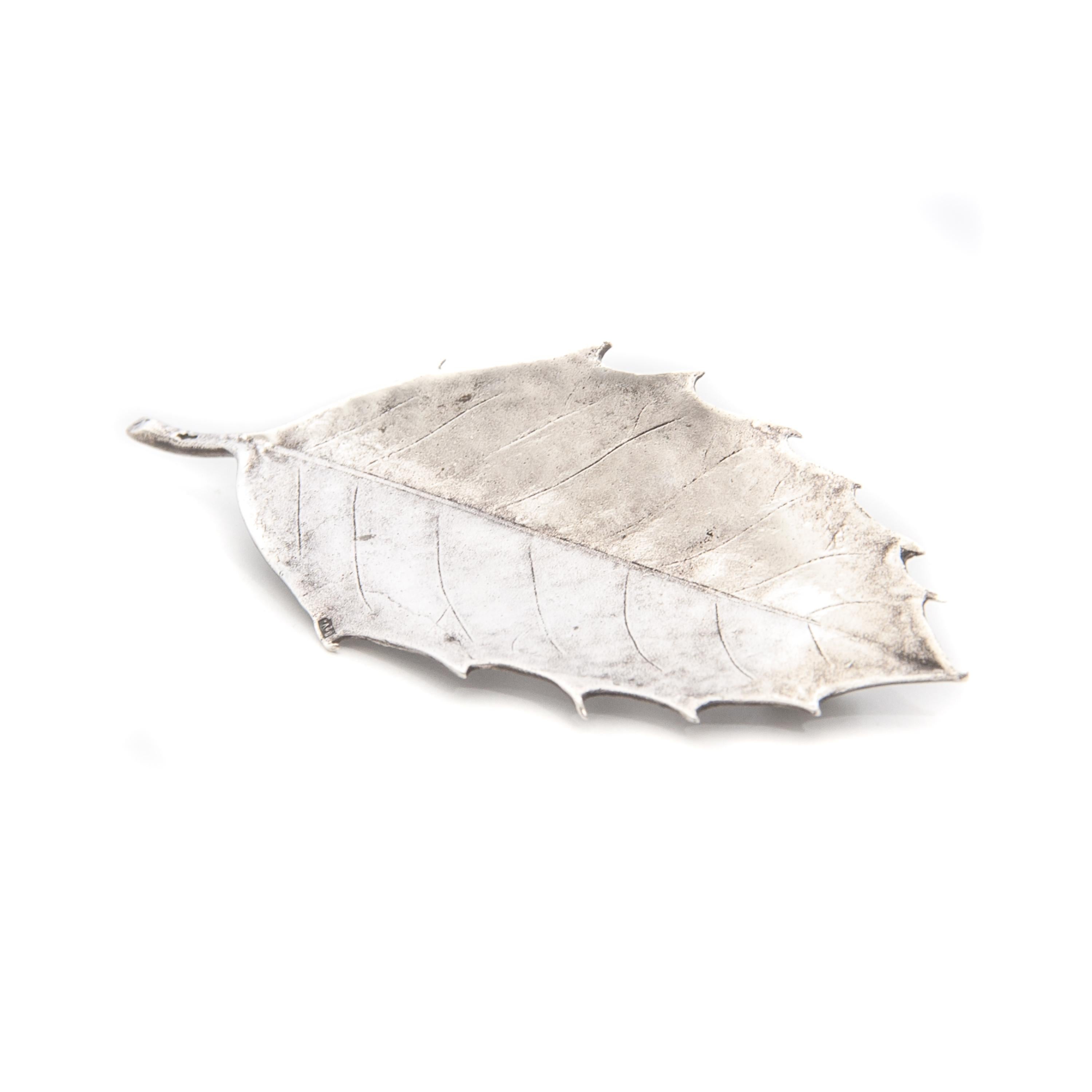 Vintage silver holly leaf prickly brooch. Known for its shiny evergreen leaves and bright red berries, holly trees are a naturally festive decoration seen throughout the Christmas season. The brooch is made of polished silver and beautifully