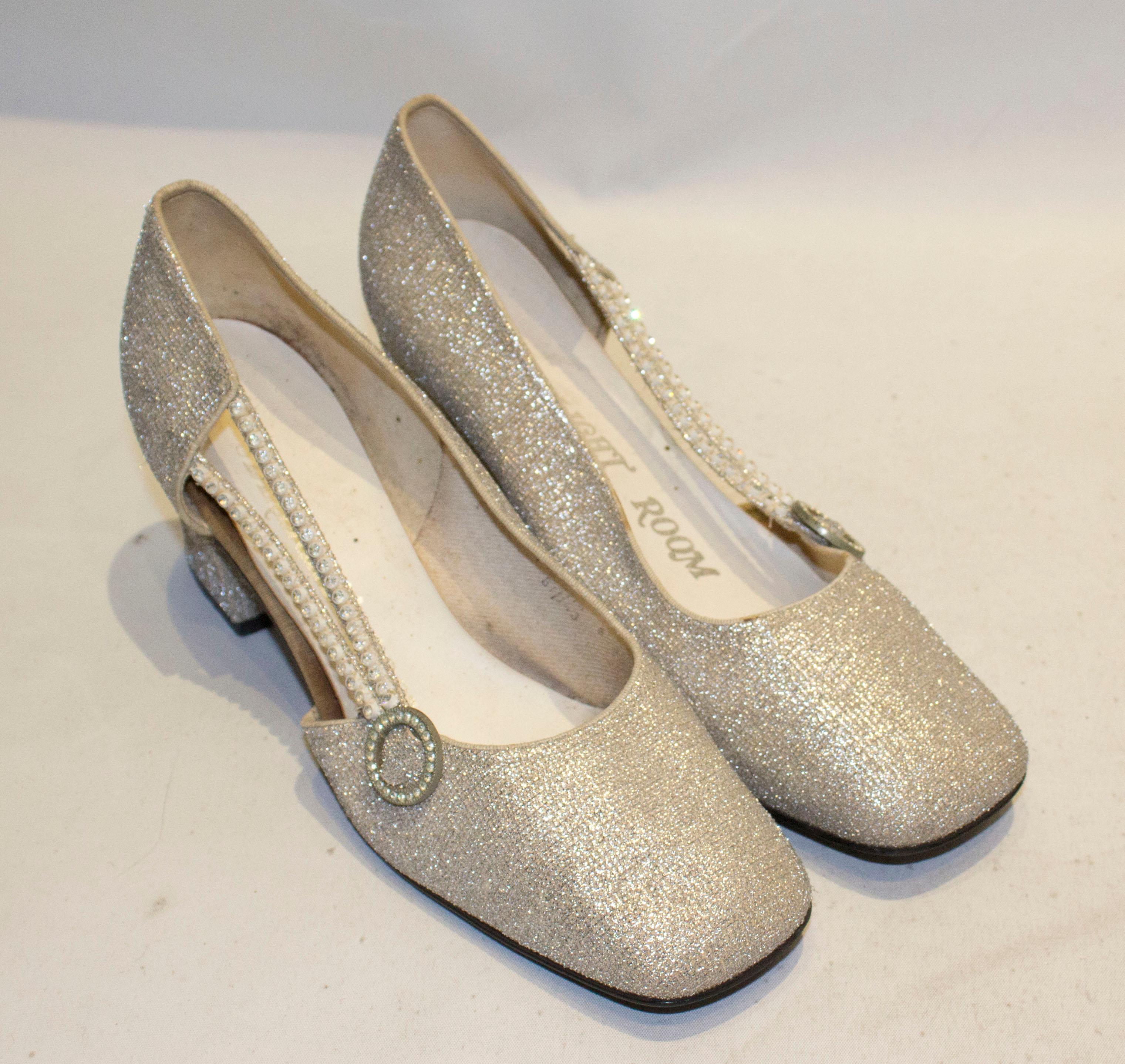 A fun pair of silver shoes by Starlight Room. The shoes have a 3'' heel, and two diamante strips along one side.  Size 8 1/2 B.