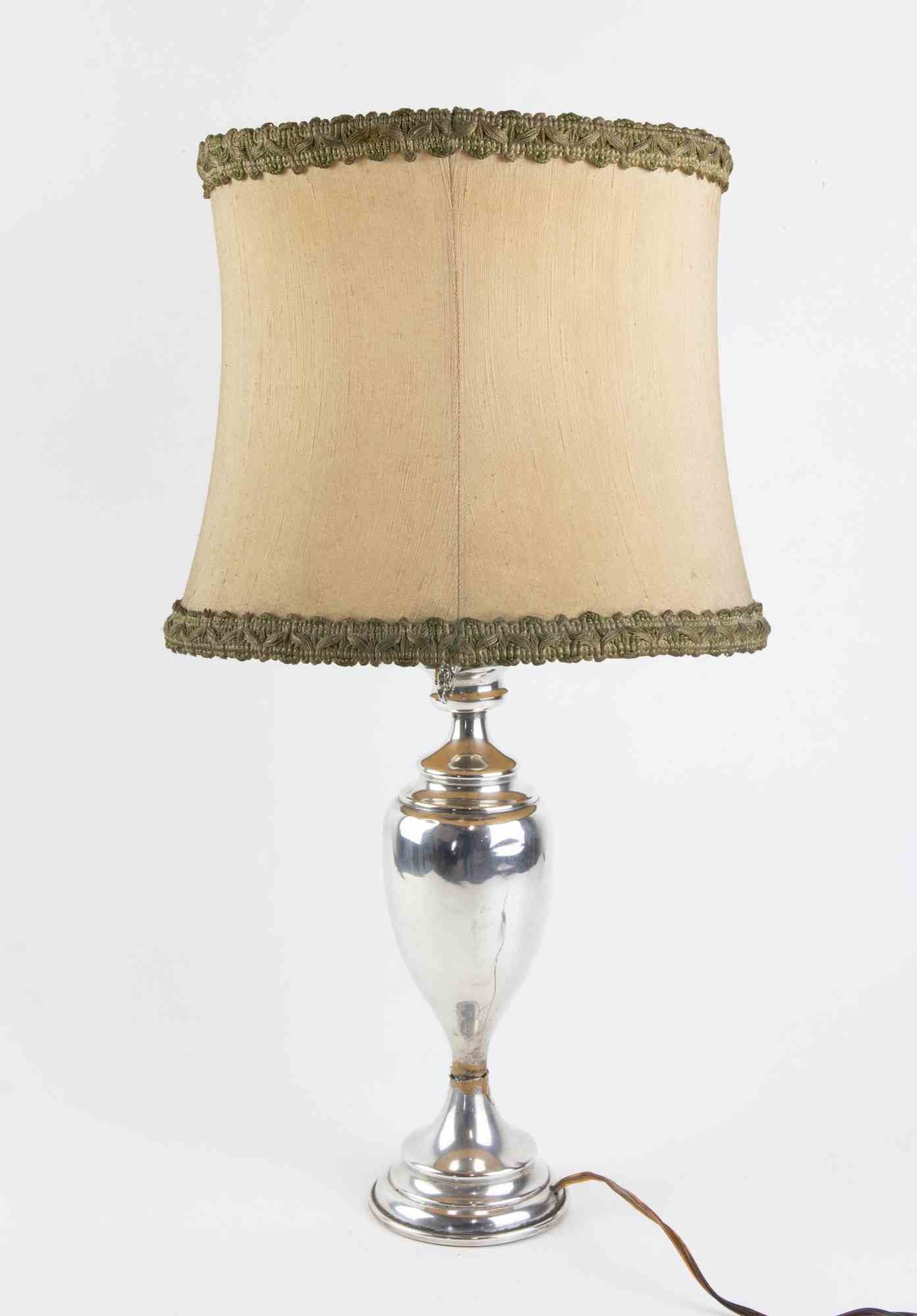 Lampe de table vintage en argent réalisée en Italie au milieu du 20ème siècle.

Diamètre : sommet 20 cm ; base 7 cm

Bon état.