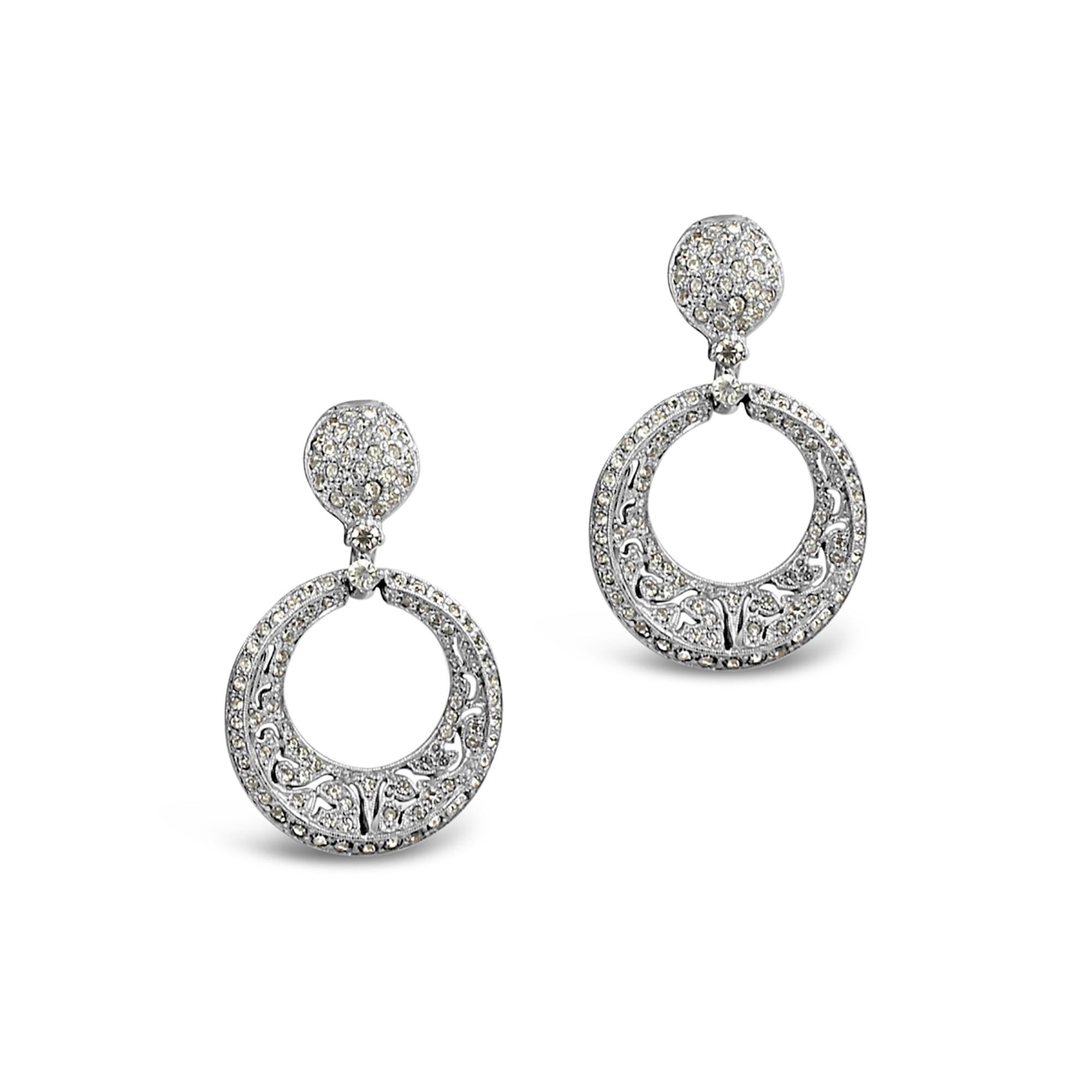 Pendientes vintage de aro con diamantes en tono plateado, alrededor de los años 80. Estos pendientes son muy finos. No se fotografían nada bien. Son de pavé y con dimensión, ya que hay recortes y también distintas capas. Se curvan hacia el interior