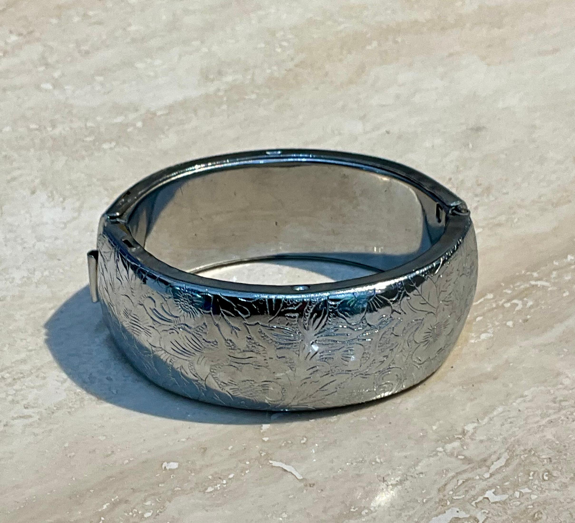 Ce bracelet à charnière floral vintage en argent est un bijou élégant et intemporel qui allie un design classique à un motif inspiré de la nature. 

La caractéristique principale de ce bracelet est le motif floral. Le design peut présenter des