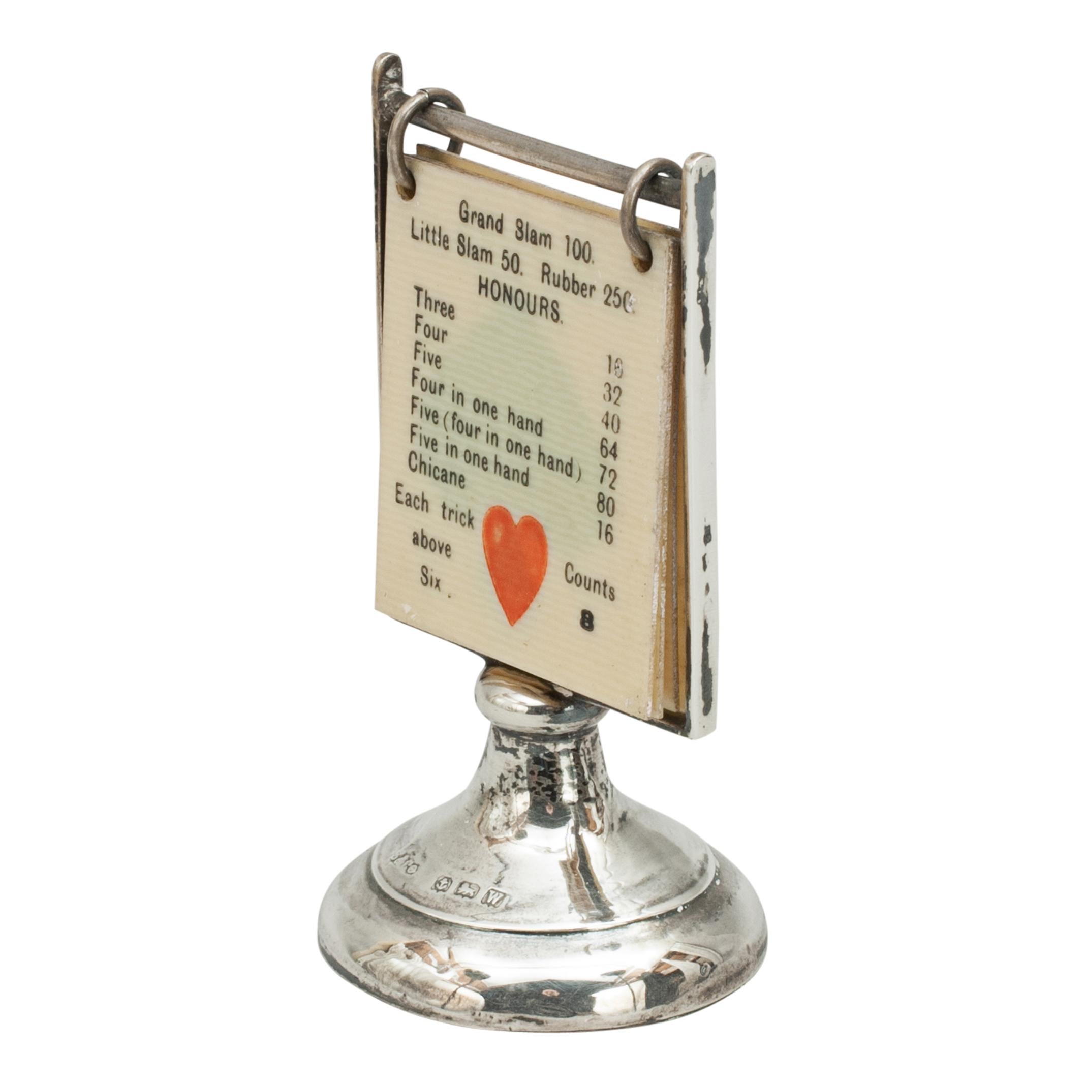 This is an excellent example of a trump card indicator for the game of Bridge. Hallmarked Birmingham silver (1946) on a circular pedestal base with ivorine squares to show the trump suit, Hearts, Clubs, Diamonds or Spades and score. There is also a