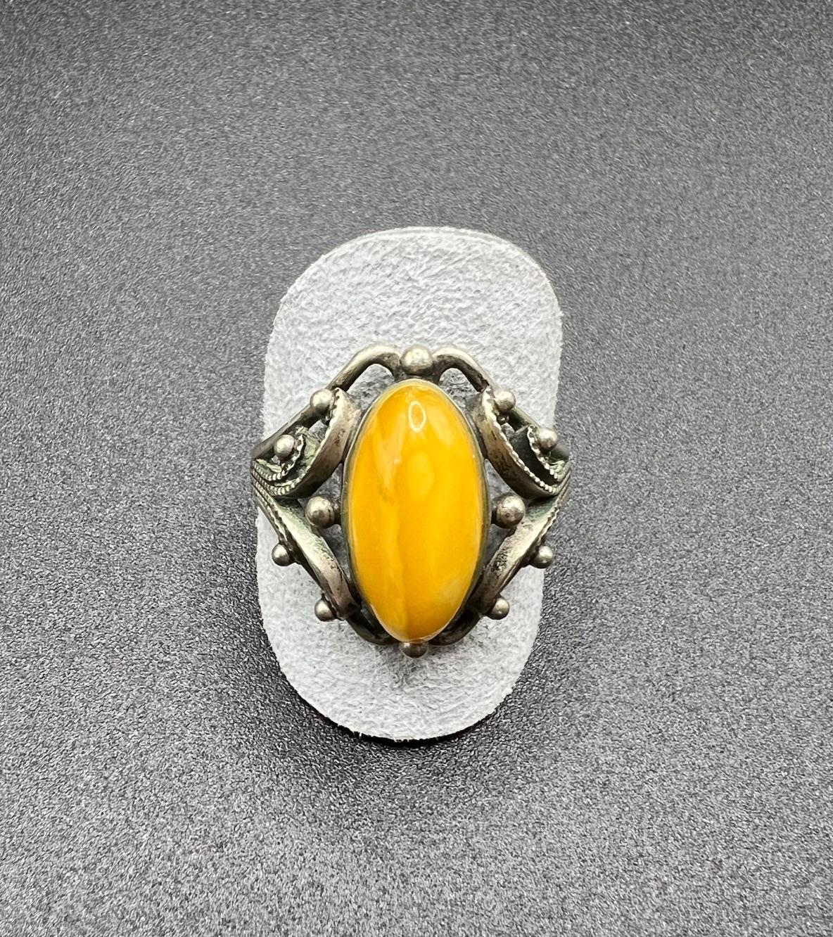 Yellow amber cabochon ring handcrafted in Latvia. This early amber jewelry is quite rare in its traditional Latvian jewelry craftsmanship and all one of a kind. The ring has not been cleaned whatsoever and the oxidation of the sterling silver metal