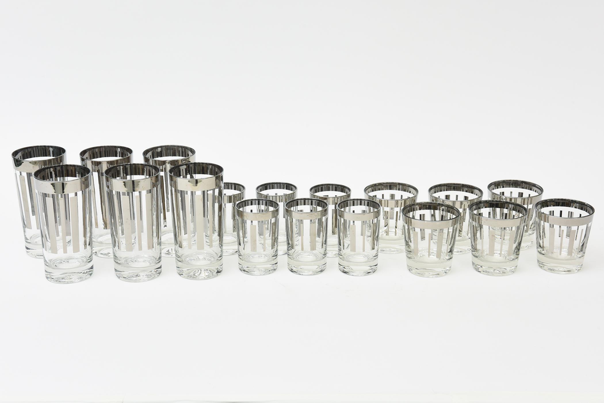 Questo set di 18 bicchieri da bar vintage della metà del secolo scorso, di 3 diverse dimensioni, è molto chic grazie alle sue linee geometriche argentate che si contrappongono al vetro trasparente. Dagli anni '50. Ci sono 6 bicchieri per ogni