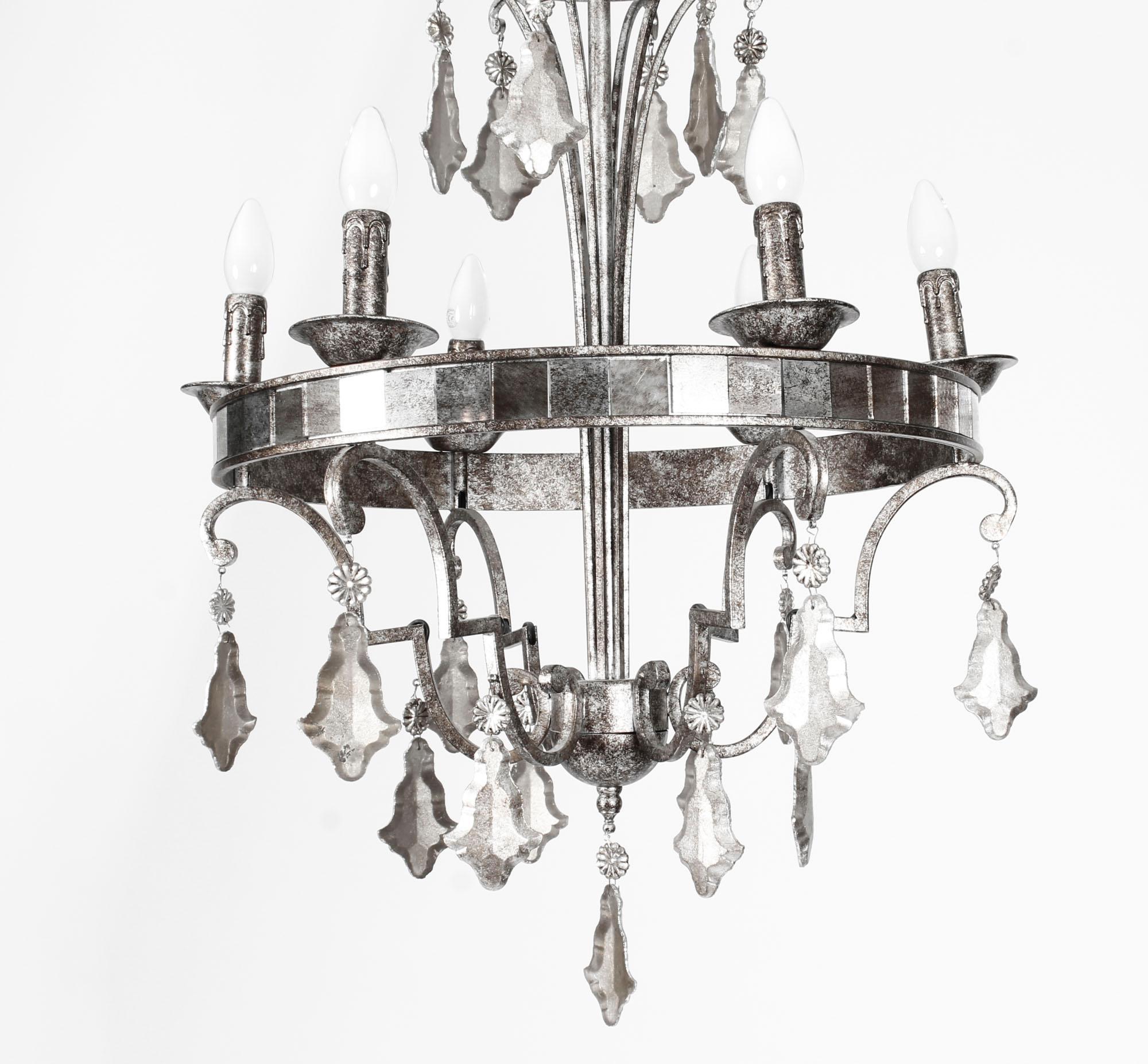 This is a highly decorative six-light cage chandelier, late 20th century in date.

The silvered bronze frame supports six candle lights and is decorated with mirrored glass and silvered faceted cut glass drops.

Add an elegant touch to any room
