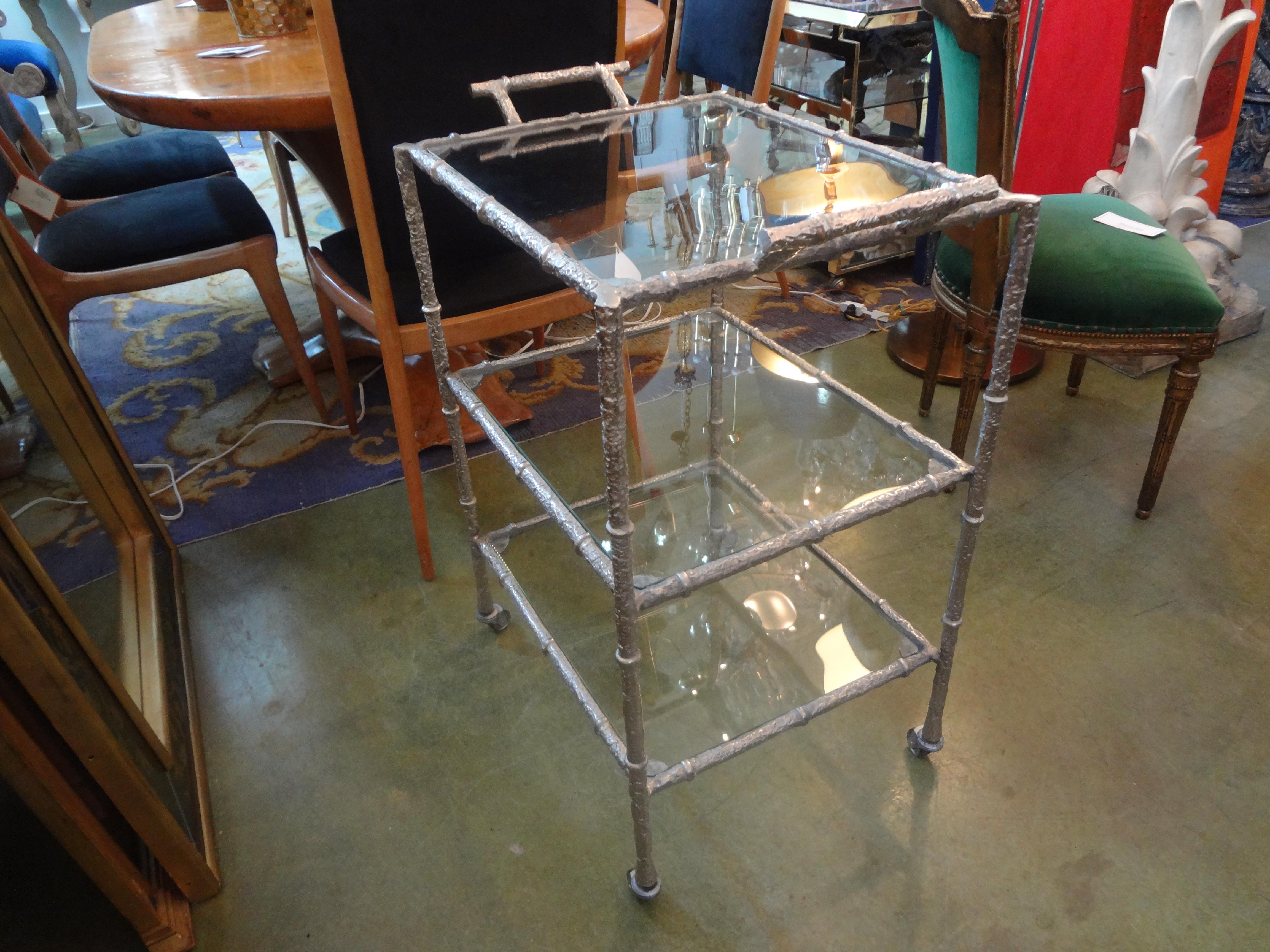 Vintage silvered metal three tiered bar cart.
Stunning vintage Maison Baguès style silvered metal three tiered bar cart, serving cart, or drinks trolley. This versatile drinks cart has three levels with glass shelves and great working casters.