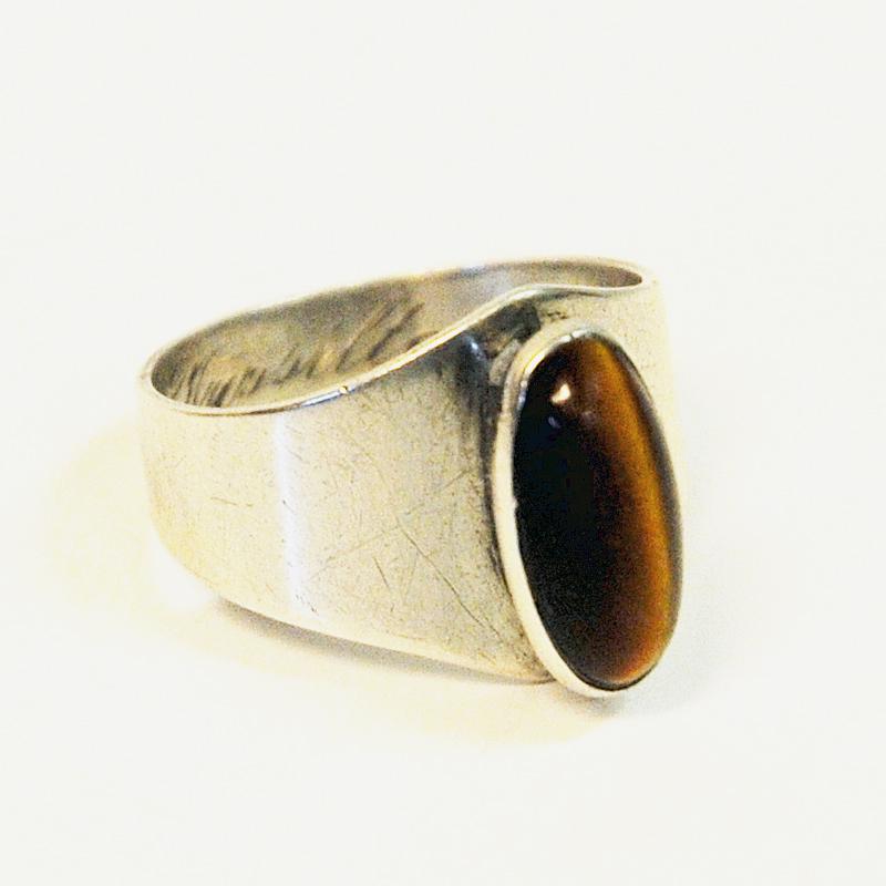 Petite vintage silverring with a lovely oval tiger eye stone by Kultaseppä Salovaara, Åbo, Finland. The ring is marked with Salovaaras hallmark Polar Bear and 825 with year stamp I7 for 1961.

Measures: Inner diameter is 16 mm, height of ring 31