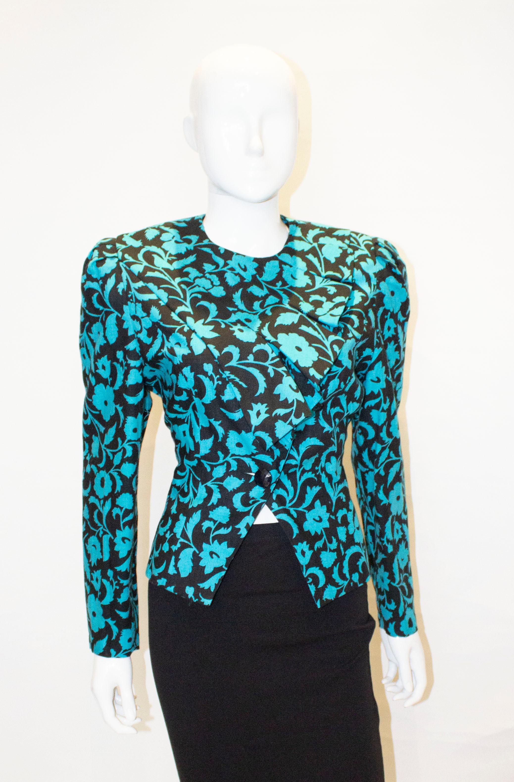 A great vintage jacket by Simon Ellis, gold medal collection. The jacket is in  an attractive  turquoise and black print with frill detail. It is fully lined, and model number CA 0138.