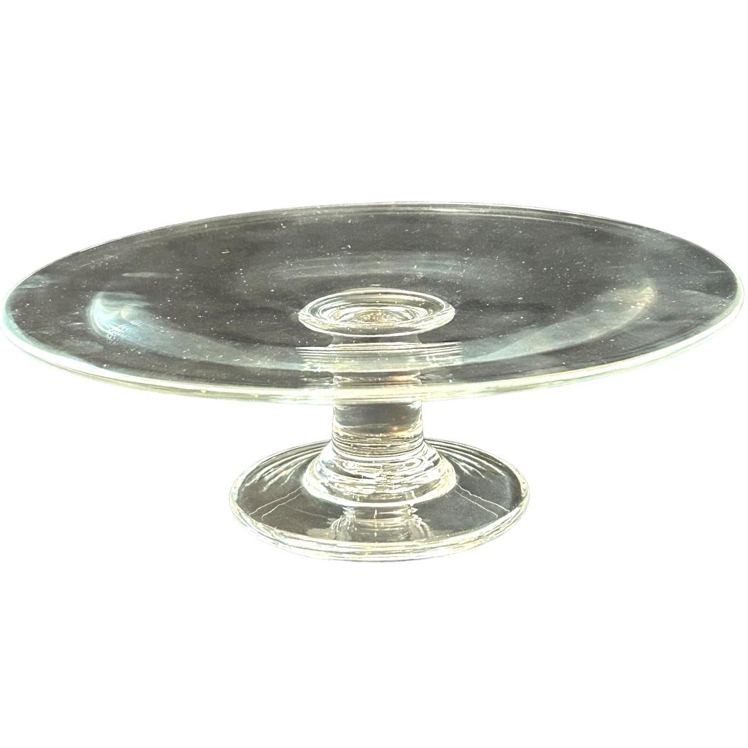 This vintage Simon Pearce crystal cake plate is a stunning addition to any collection.  Crafted with exquisite attention to detail, it’s the perfect choice for showcasing your favorite desserts.  Measuring approximately 10.75” in diameter, it’s the