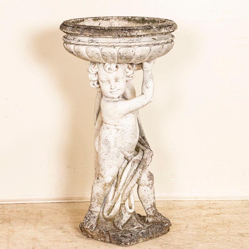 The attractive worn patina of the cement comes from years of use as a birdbath in the French countryside. Knicks, minor cracks, old lichen are all typical age related wear and indicative of the years spent outdoors as a garden sculpture with
