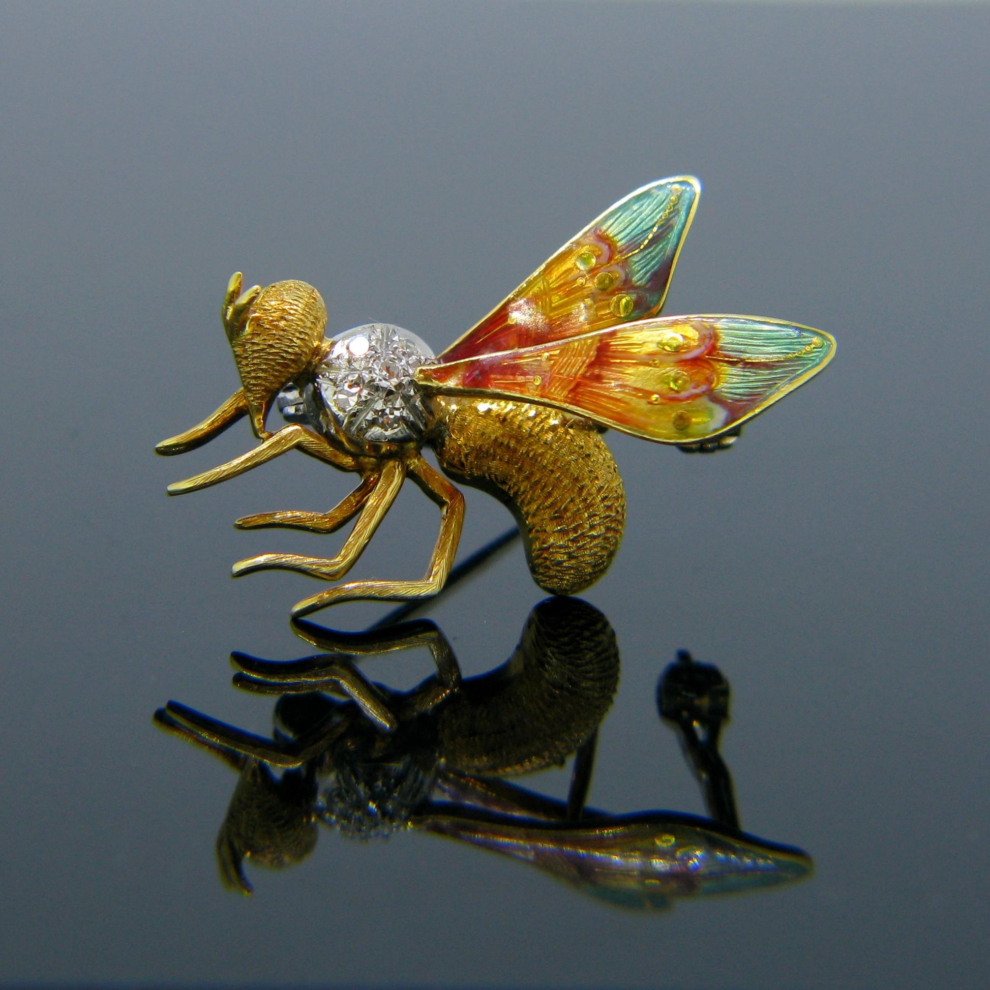 This beautiful brooch represents a wasp; it is set with 5 single cut diamonds and the wings feature vibrant colours of orange, yellow and green enamel. The enamel is in good condition. It is fully made in 18kt yellow gold and the diamonds are set in