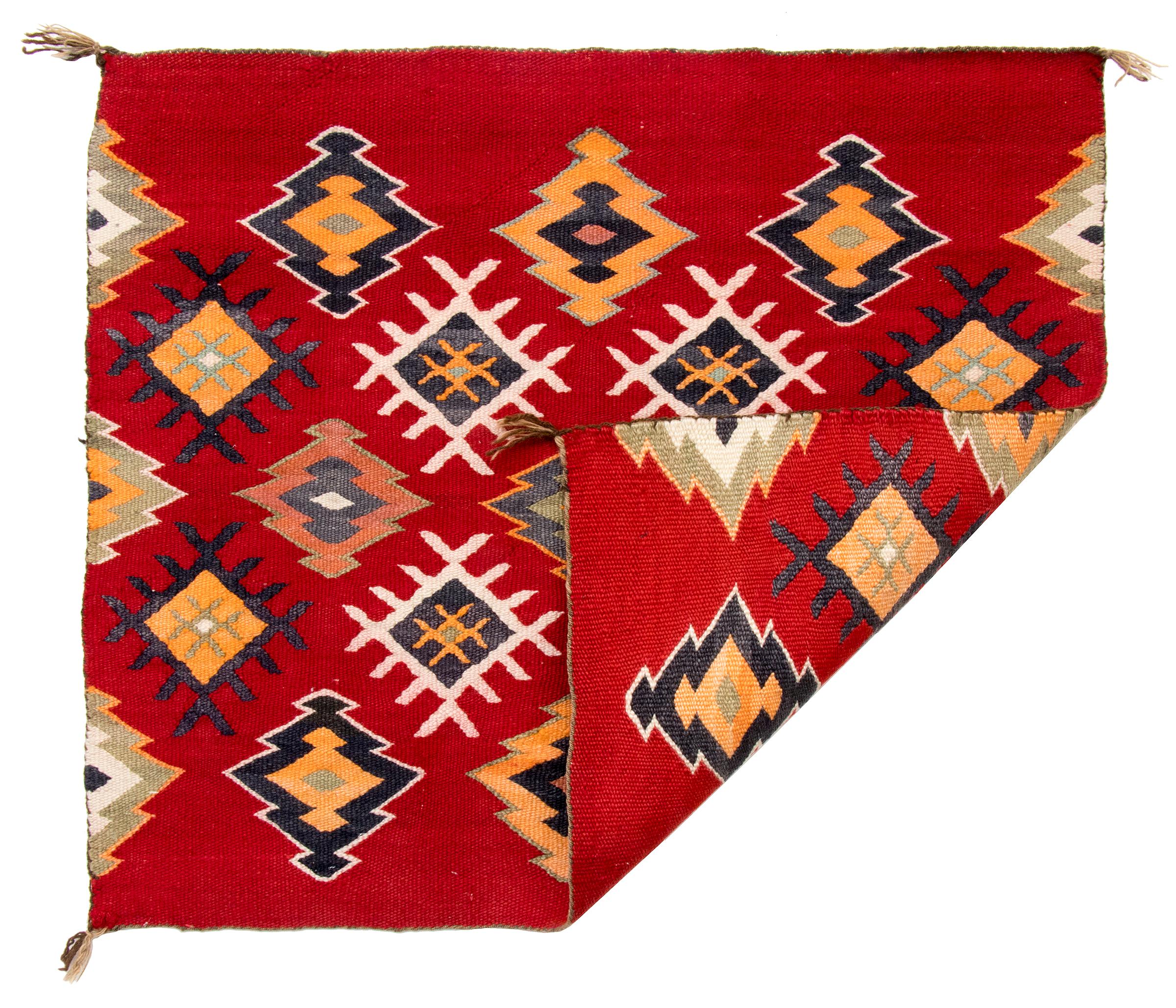 Vintage early 1900s Navajo single saddle blanket with diamond pattern, hand woven of native hand spun wool in red, yellow, orange, black and white. 
The Diné (Navajo) peoples are a Native American Indian tribal group indigenous to the area now known