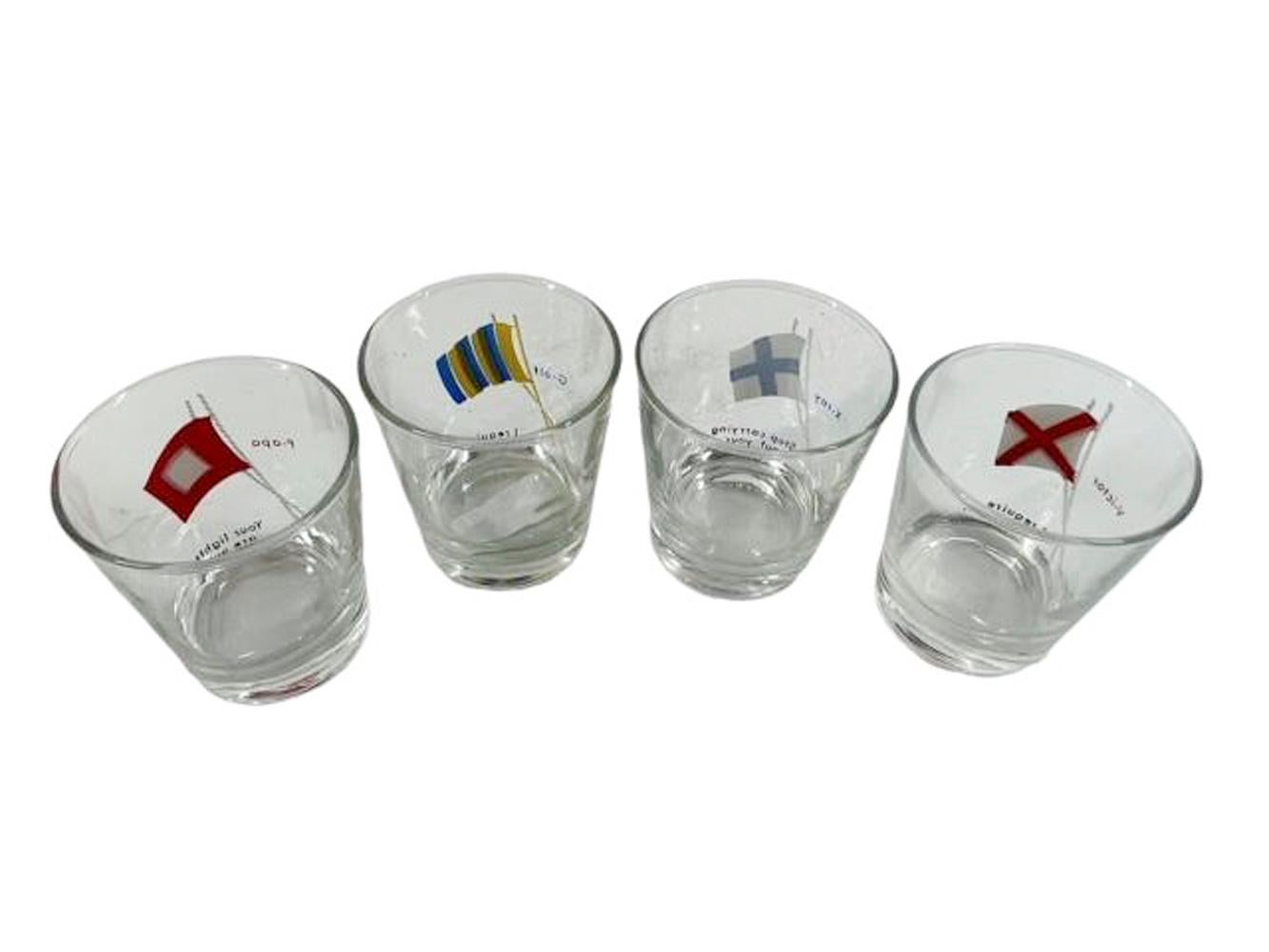 Vintage set of 4 old fashioned bar glasses in clear glass, each painted with a different nautical flag. To the left of each flag is the letter/word meaning and below each is a suggestive phrase.
