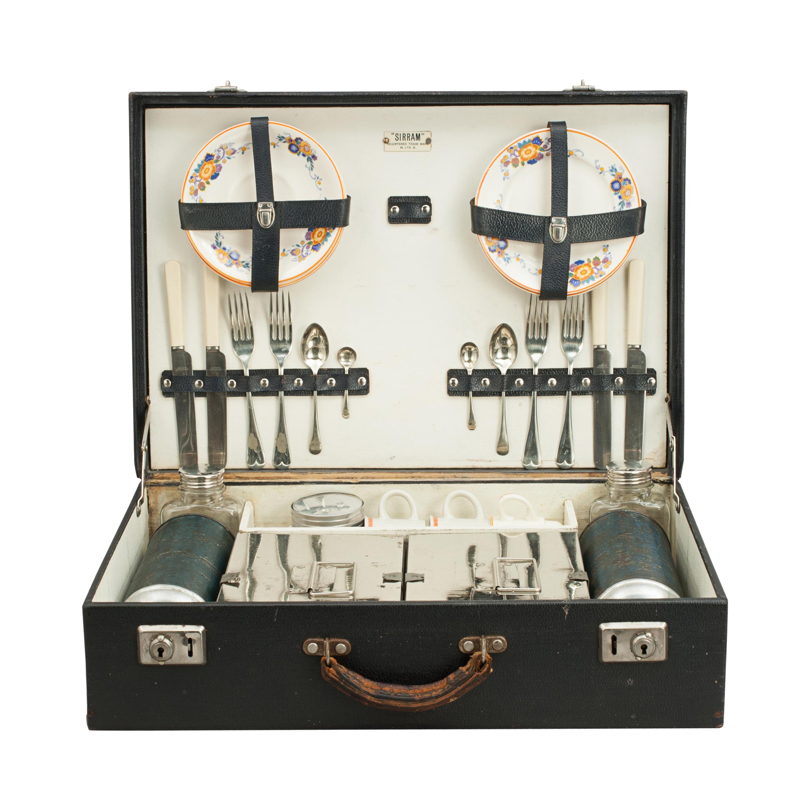 A great mid-20th century four-person picnic set in a carry case. The wooden carcus is covered in black cloth with two nickel-plated locks and catches, the contents in a good neat compact setting, held in place in the lid by leather straps. This is a