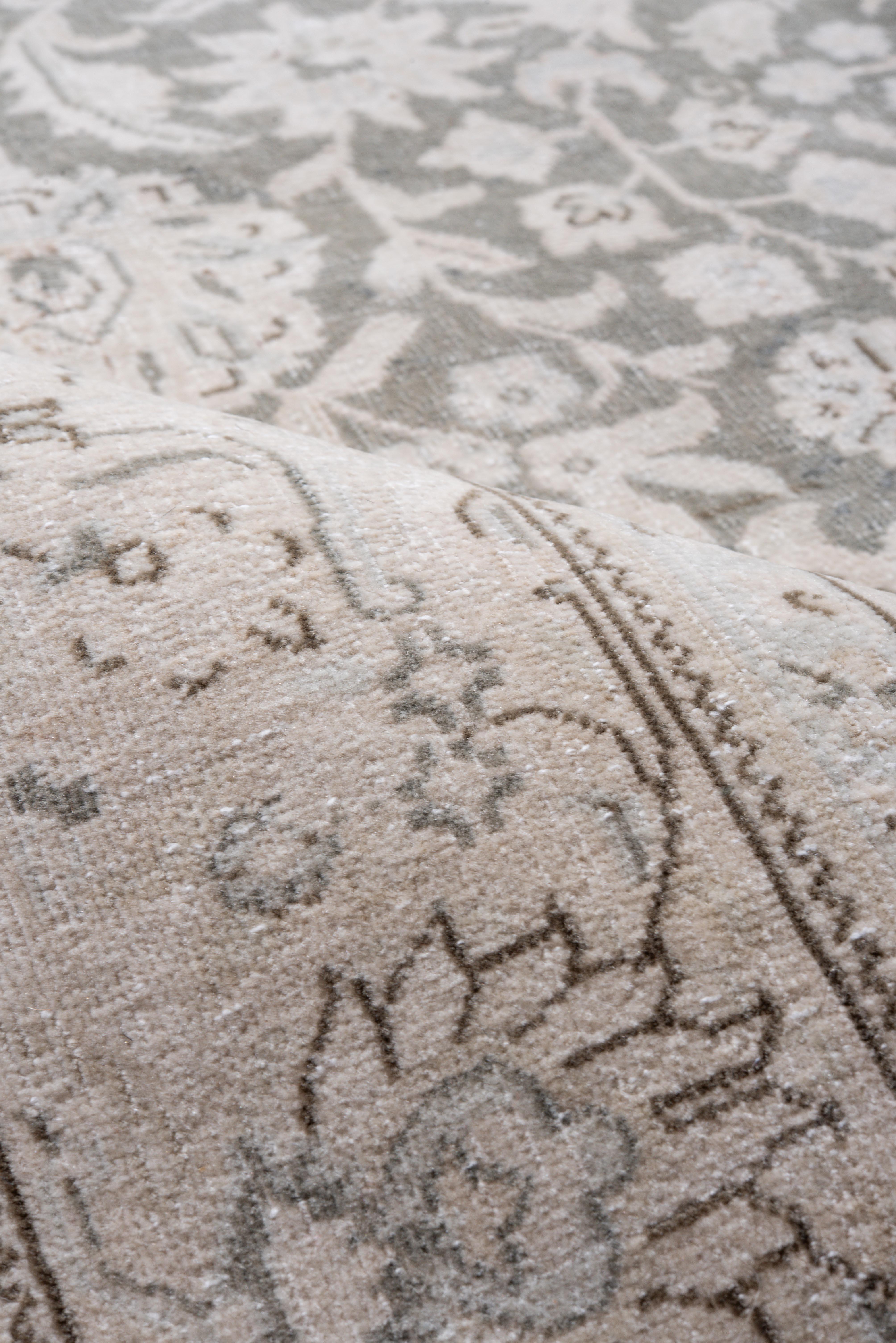 Su un morbido fondo grigio tortora ravvivato da riflessi avorio e circondato da un bordo di protezione beige pergamena, questo Sivas vintage presenta una vite a scorrimento intrecciata con palmette stilizzate, boccioli di loto e delicate rosette.