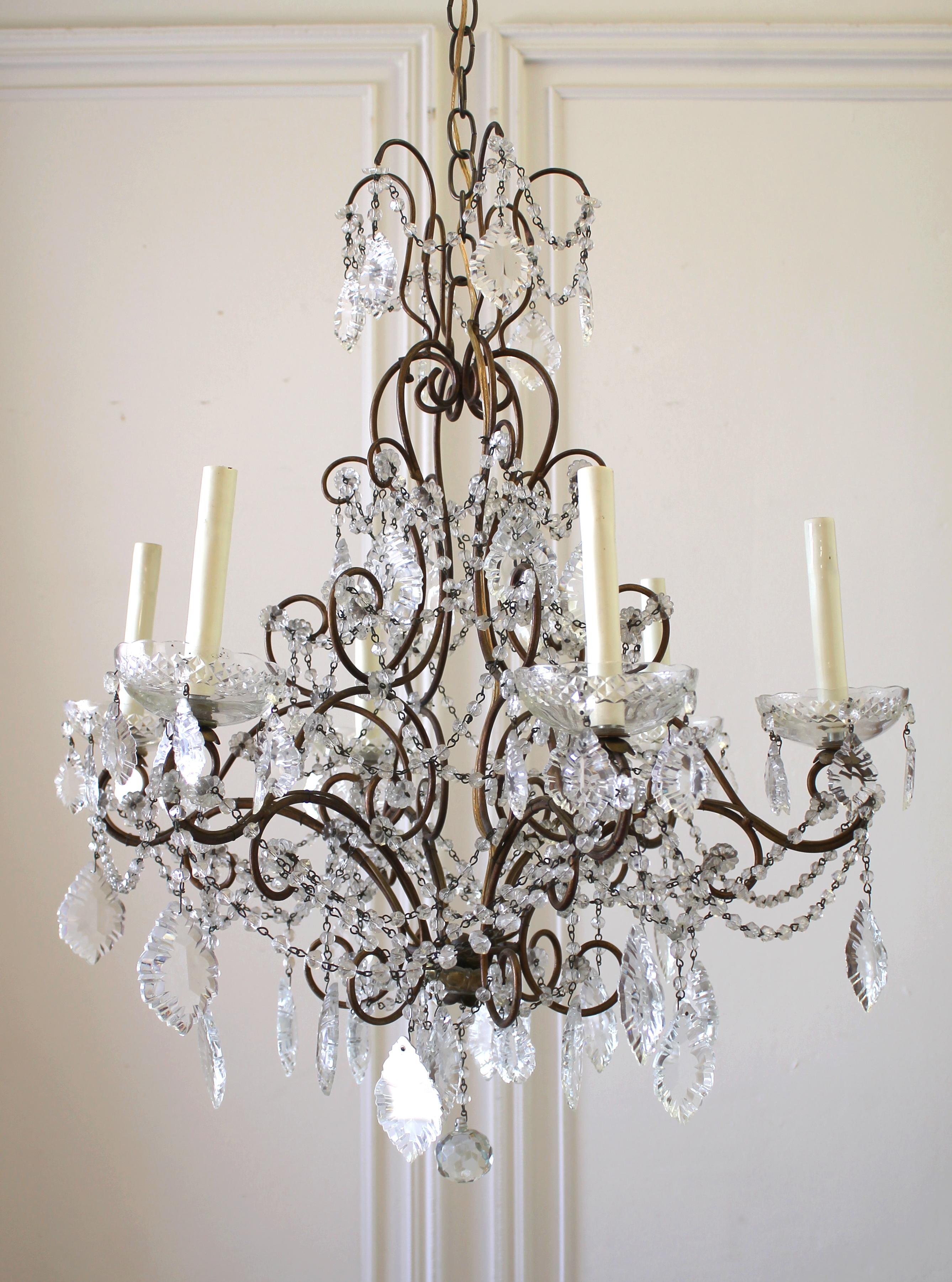 Vintage Italian Chandelier with round cut glass beads, and French crystal pendants. Large glass bobeches, with one of them being repaired (see photos). Bulbs have been placed in each socket and are working.
Measures: 25