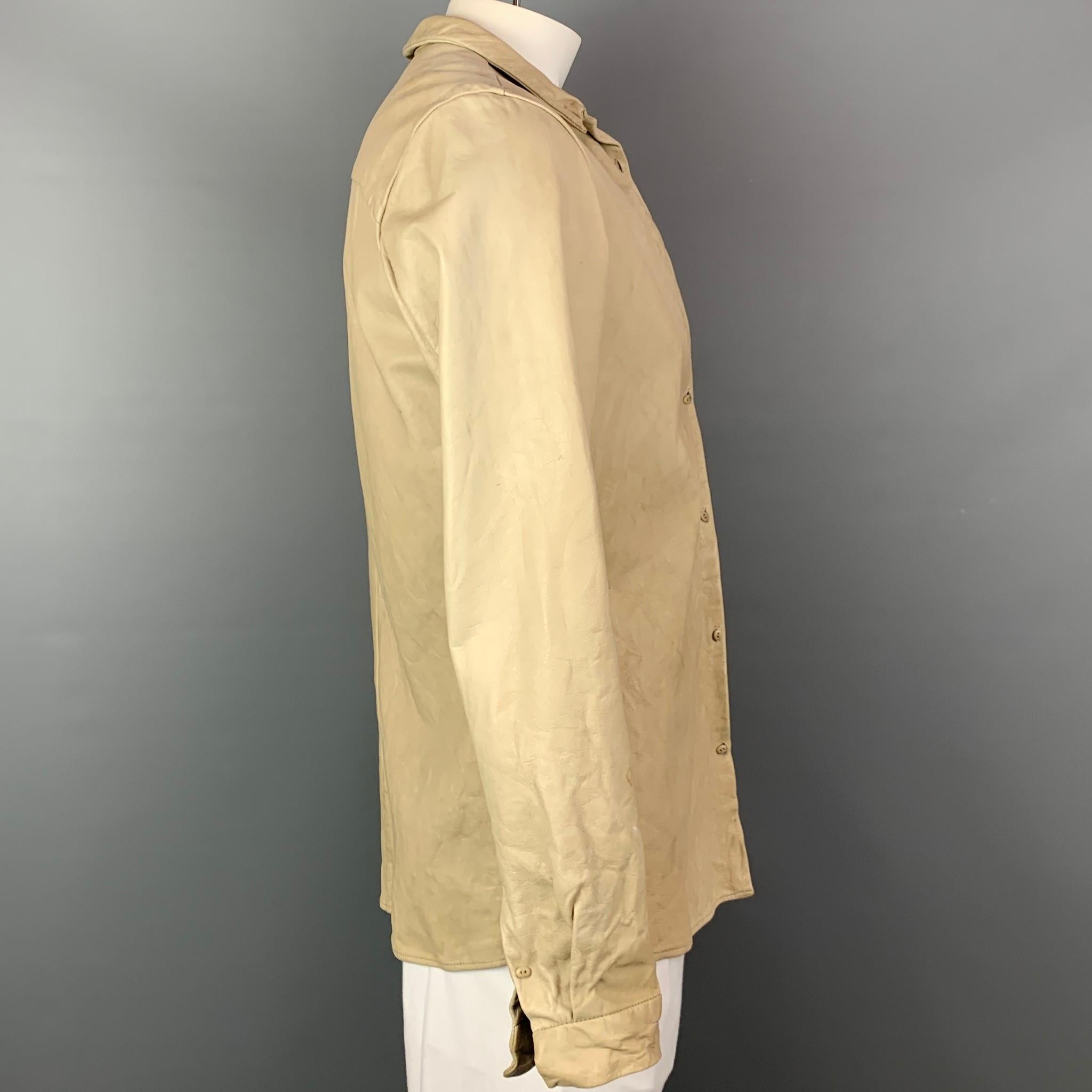 VINTAGE jacket comes in a beige leather with no liner featuring a spread collar and double button closure. Missing one button, and has minor wear.

Good Pre-Owned Condition.
Marked: Missing fabric tag.

Measurements:

Shoulder: 18 in.
Chest: 42