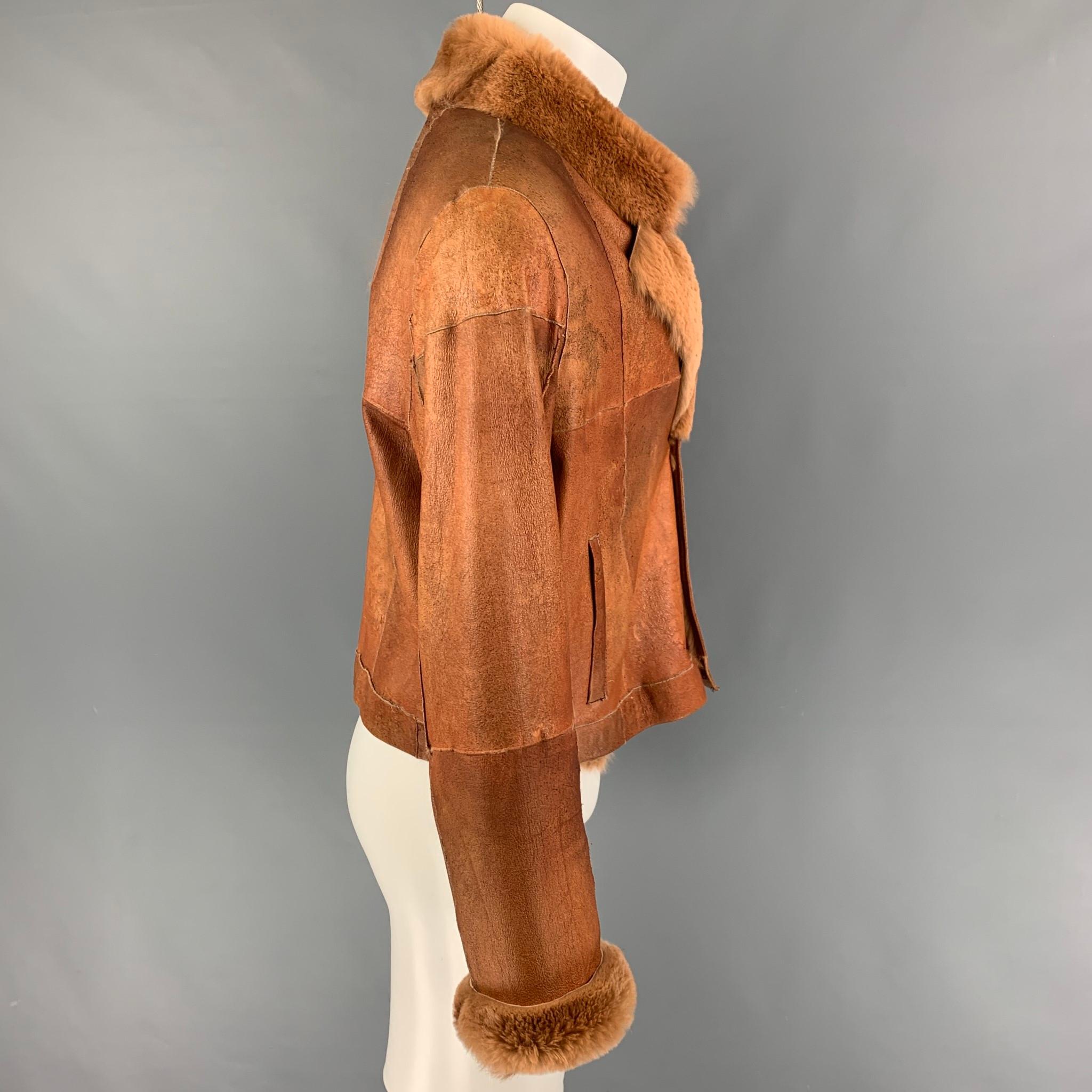 VINTAGE jacket comes in a tan distressed leather with a shearling interior featuring a cropped style, slit pockets, and a buttoned closure. 

Good Pre-Owned Condition. Fabric tag removed.
Marked: Size tag removed.

Measurements:

Shoulder: 19