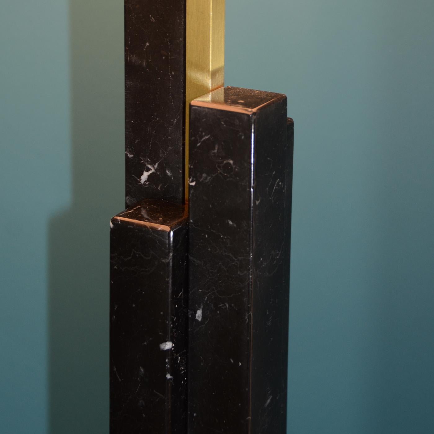 La collection Skyline, avec ses lamelles de marbre qui s'enroulent autour du corps de la lampe, donne une impression d'élan et de stricte linéarité. La présence de l'arc qui soutient l'abat-jour rappelle la saveur vintage des modèles des années 50.