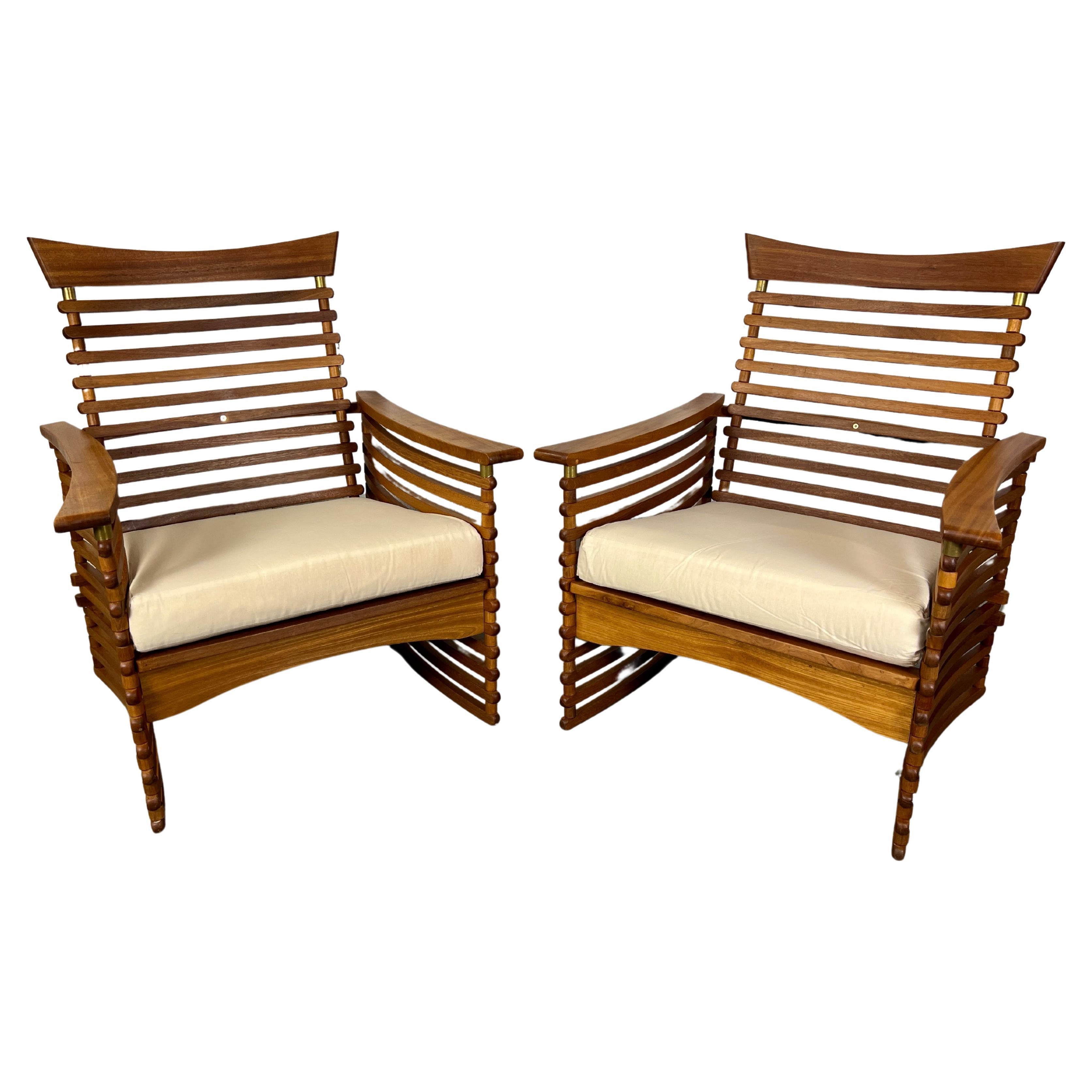 Solid teak slat lounge chairs with brass accents. The sides are curved with a nice angle on the back. These are very sturdy and very comfortable for long term sitting. 
New upholstery is required.