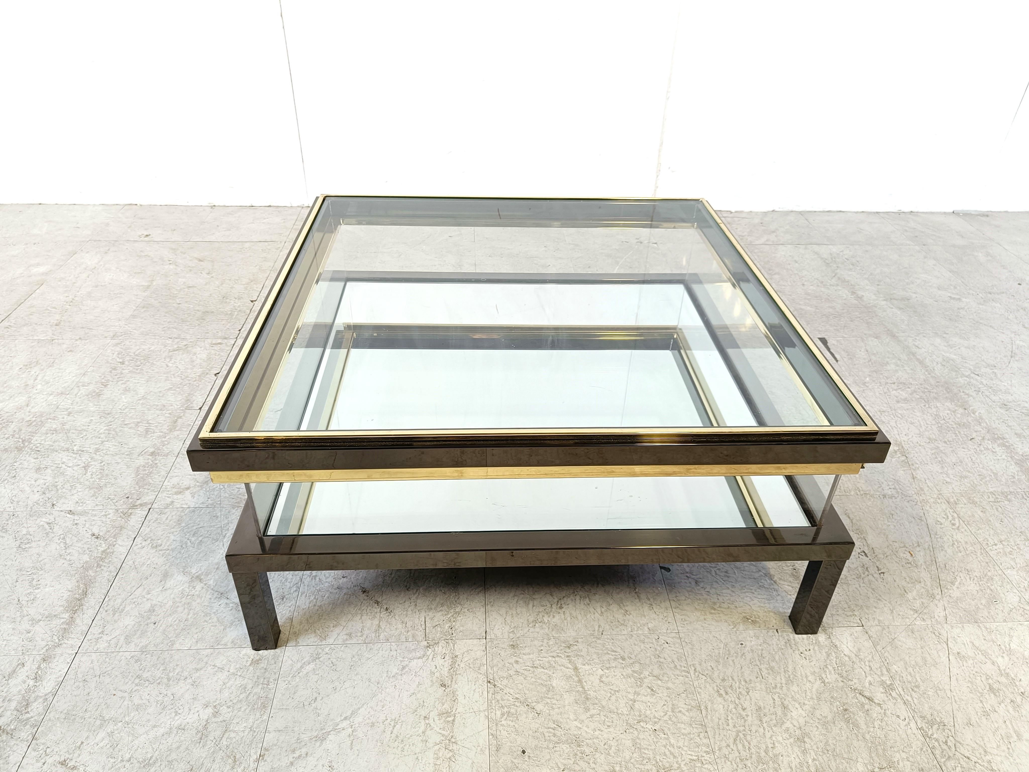 Vintage display coffee table with a sliding glass top.

This luxurious coffee table is made from heavy quality polished steel, brass and glass.

You can choose to either have it with the mirrored glass or leave it out  to reveal a storage space for