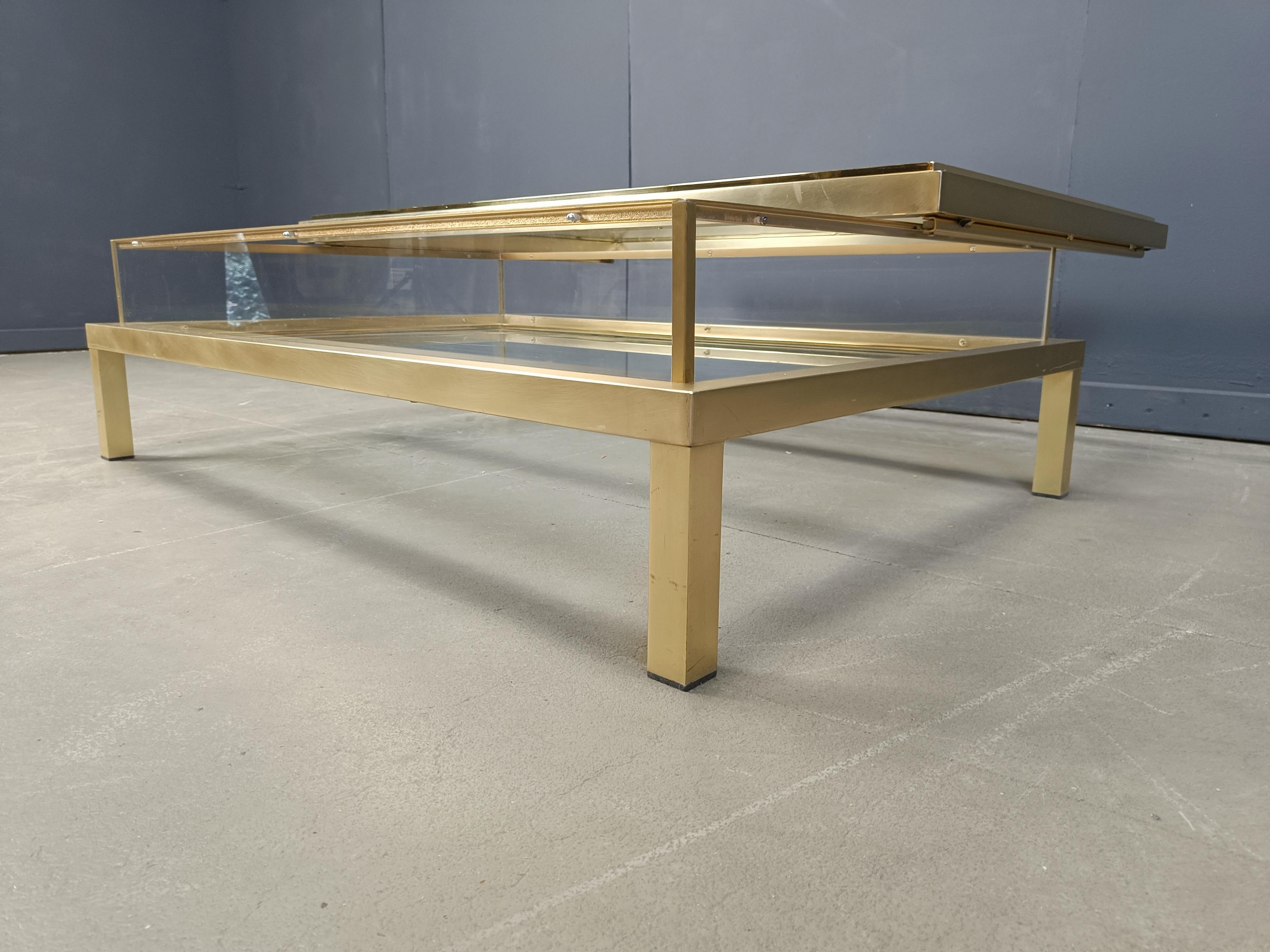 Vintage display coffee table with a sliding glass top by Belgochrom.

This luxurious coffee table is made from brass, glass and plexi

It is ideal to display curio and store magazines.

Very good condition, near mint - unseen given its age

1970s -