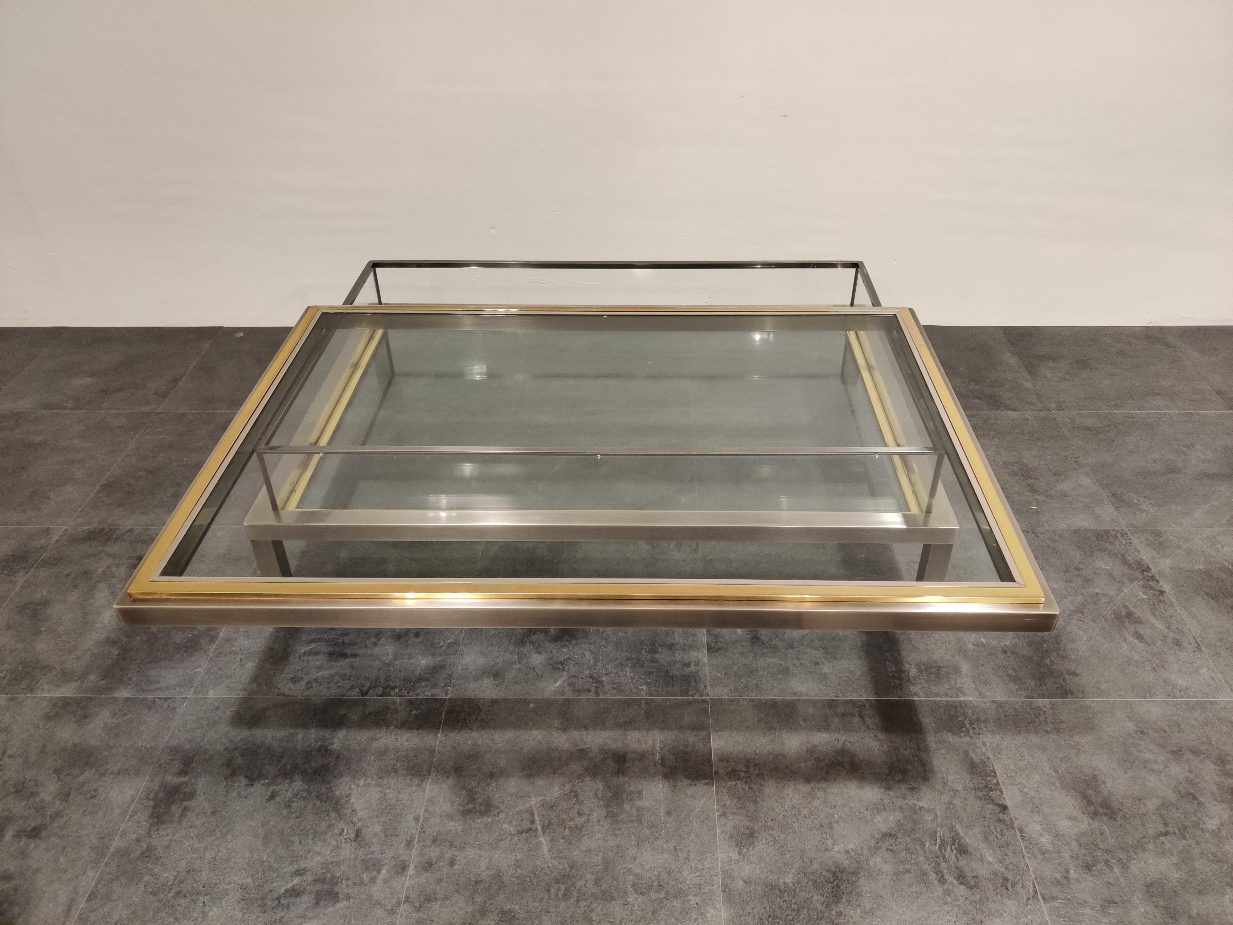 Vintage display coffee table with a sliding glass top.

This luxurious coffee table is made from heavy quality polished steel, brass and glass.

It is ideal to display curio and store magazines.

Perfect condition, like new,

1970s,