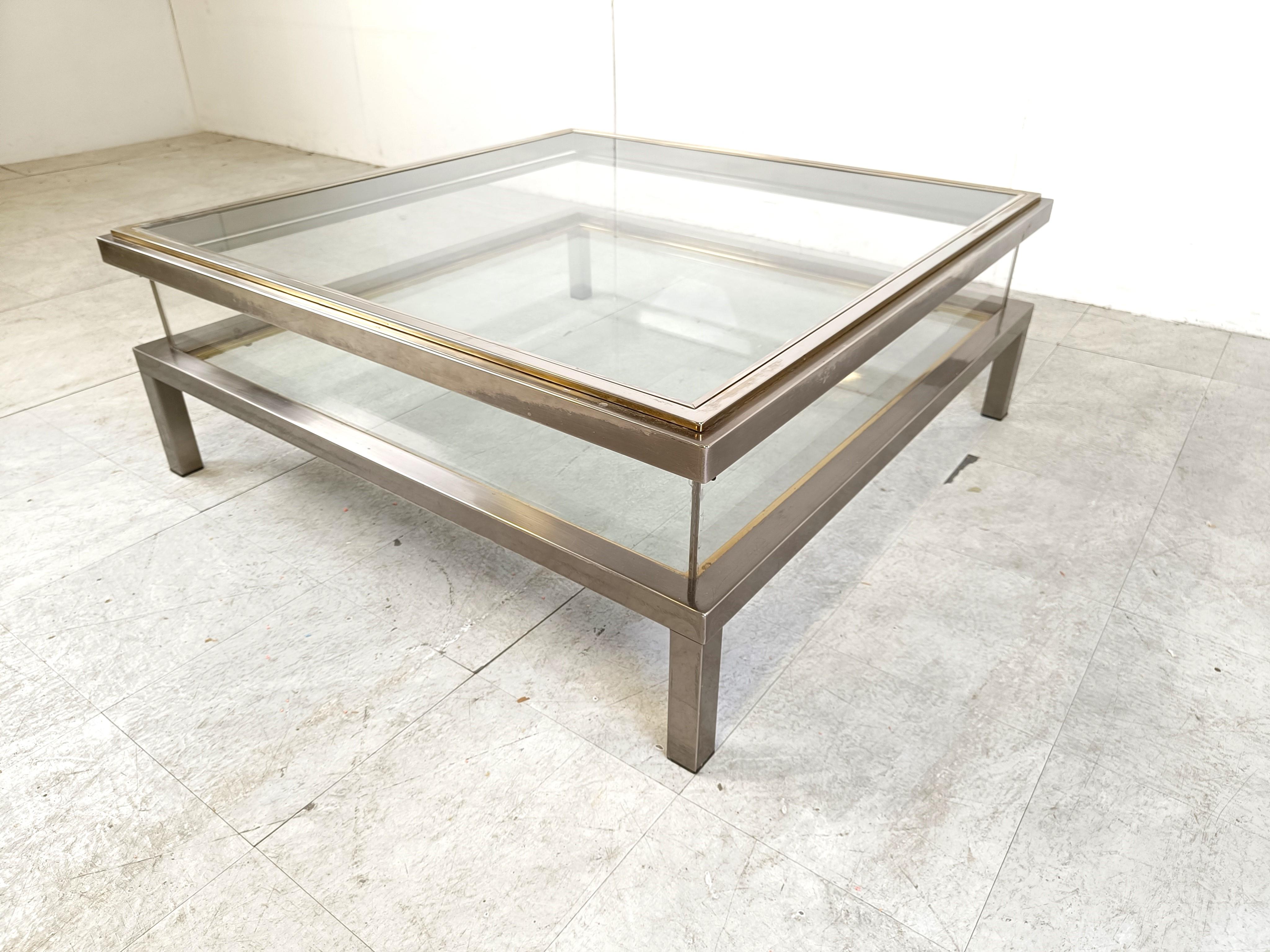 Vintage display coffee table with a sliding glass top.

This luxurious coffee table is made from heavy quality polished steel, brass and glass.

Very good condition.

1970s - France

Dimensions:
Height: 43cm/16.92