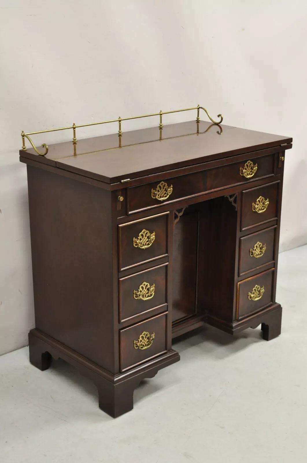Vintage Sligh Georgian Chippendale Style Crotch Mahogany Kneehole Desk. L'articolo è dotato di piano ribaltabile, galleria e ferramenta in ottone, serratura e chiave funzionanti per lo sportello centrale, retro rifinito, artigianato americano di
