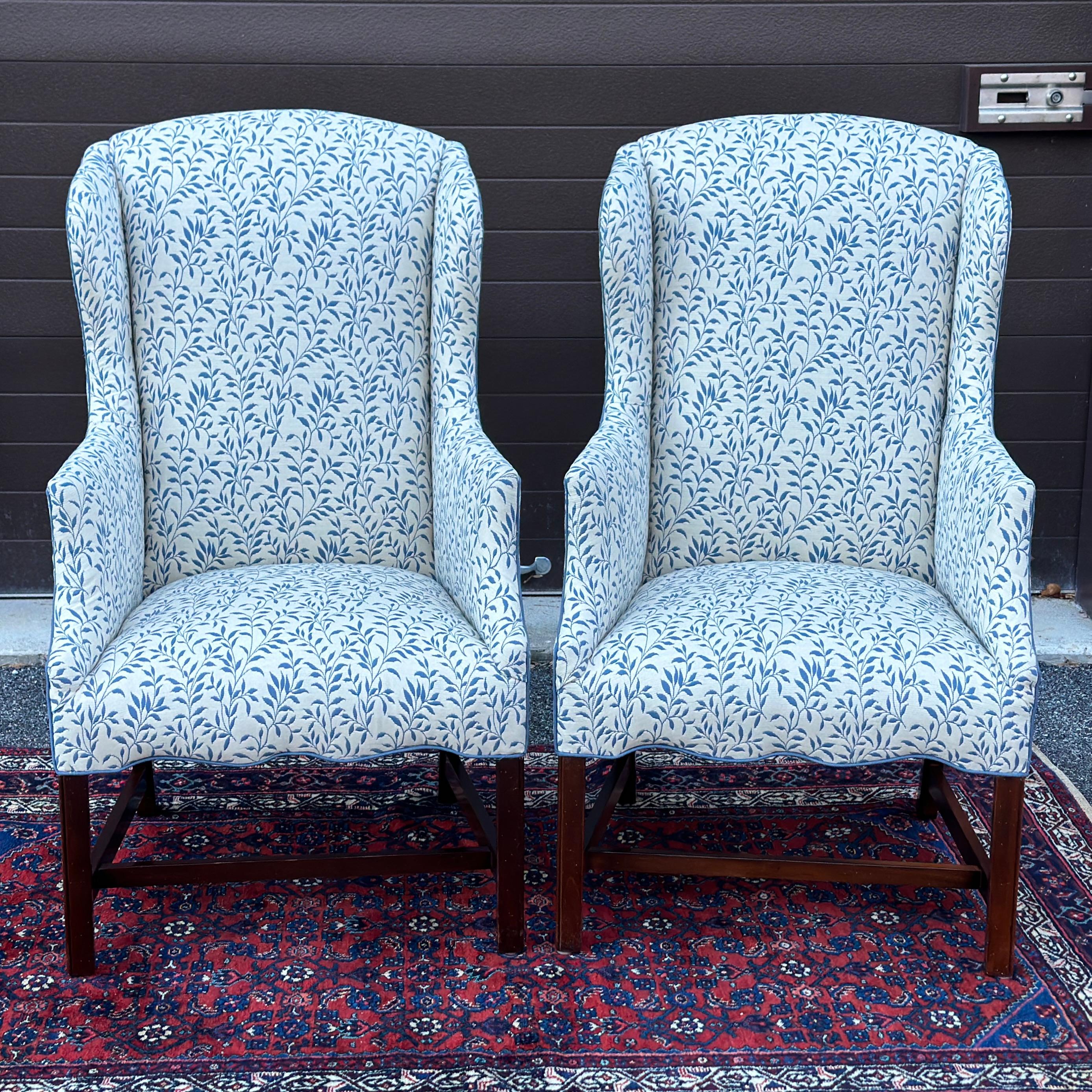 Vintage Slim Wingback Fireside Lounge Chairs recently reupholstered in a white upholstery fabric with blue branches with leaves and trimmed in blue welting. These are high quality chairs with Chippendale style legs and stretchers and a nice