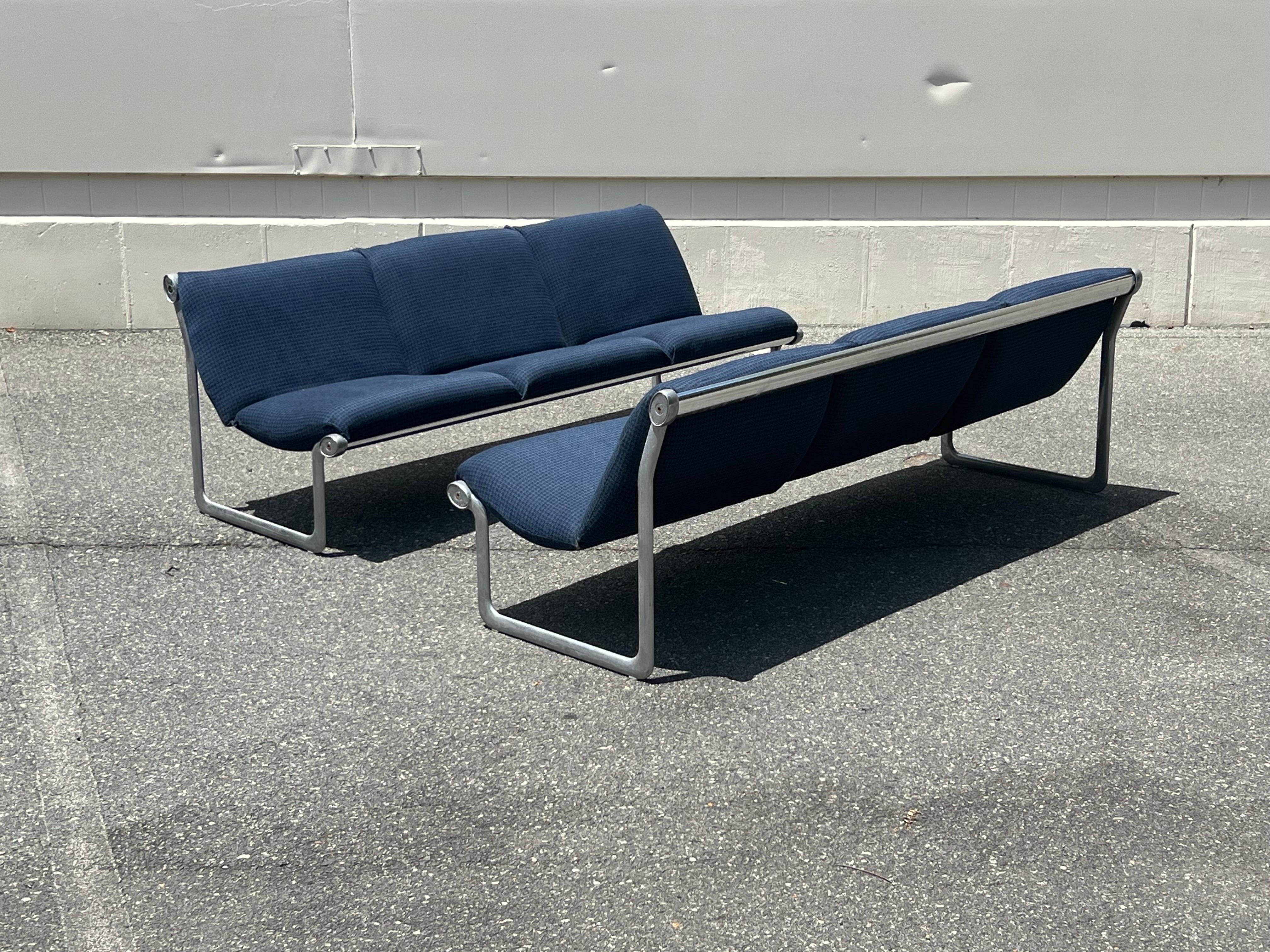Two matching three-seat settee sofas designed by Bruce Hannah and Andrew Morrison for Knoll circa 1970s. These “sling” sofas have a sleek profile and versatile feel. Equipped with aluminum legs and chrome support that the cushions float effortlessly