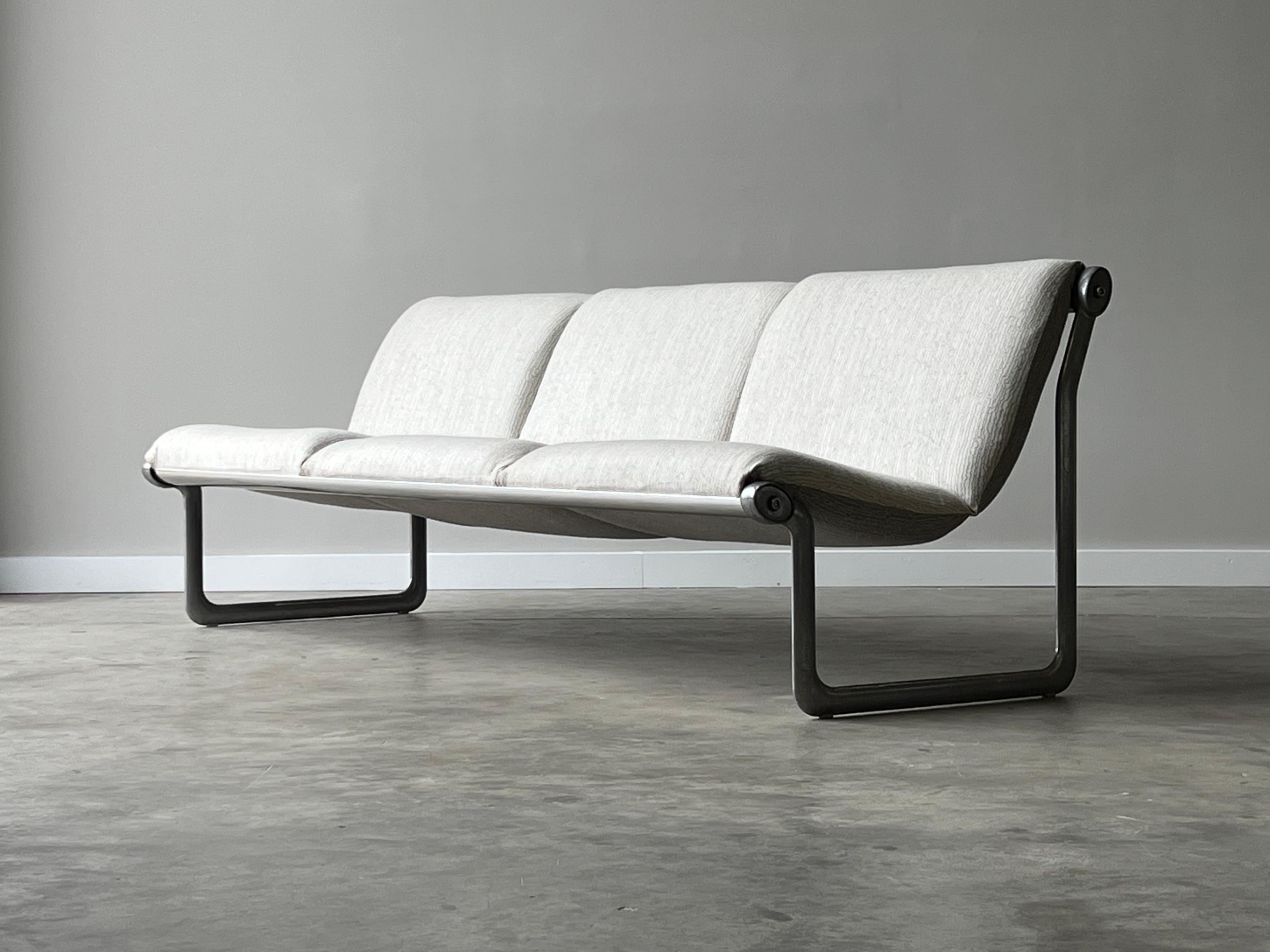 Two matching three-seat settee sofas. Designed by Bruce Hannah and Andrew Morrison for Knoll circa 1970s. These “sling” sofas have a sleek profile and versatile feel. Equipped with aluminum legs and chrome supports that the cushions float