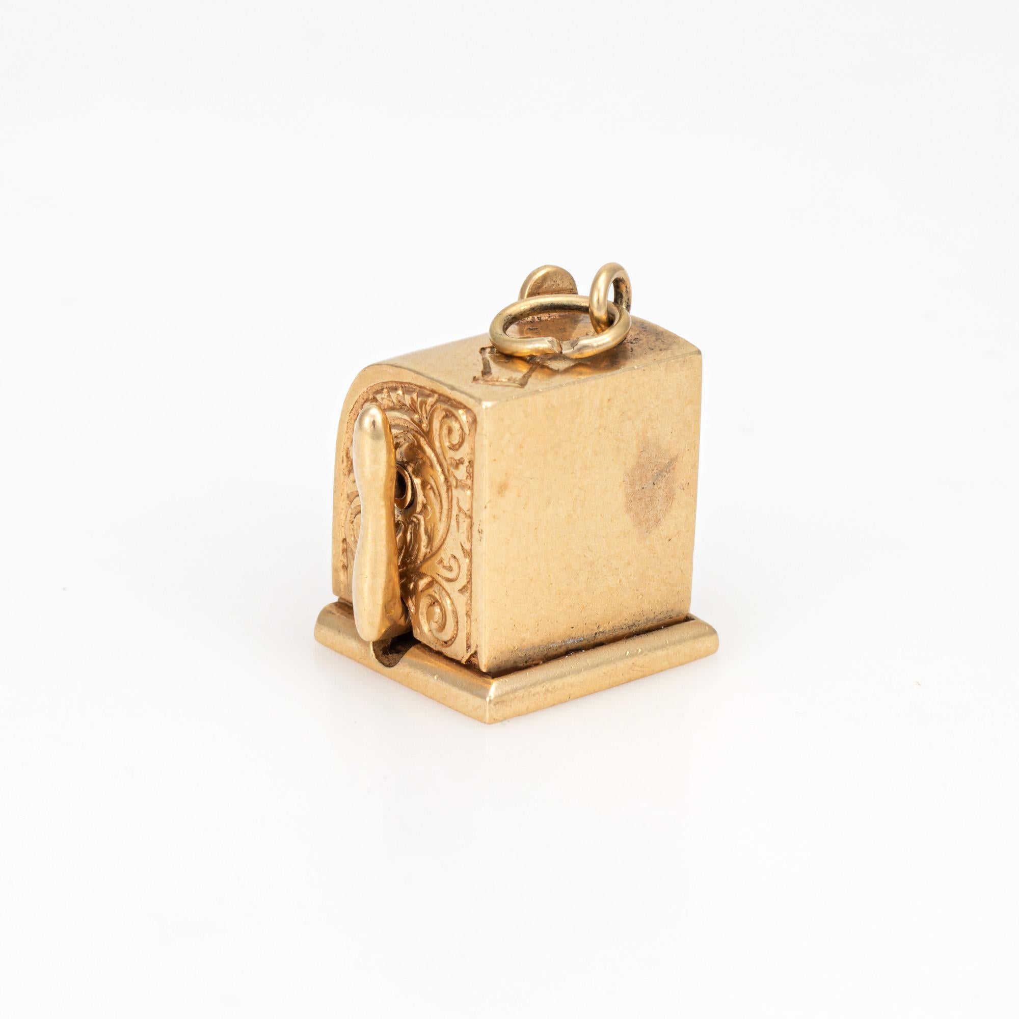 Finely detailed vintage slot machine charm crafted in 14k yellow gold (circa 1940s to 1950s).  

The nicely detailed charm features a slot machine with viewing windows highlighting depictions of fruit (cherries, lemons, oranges and pears).