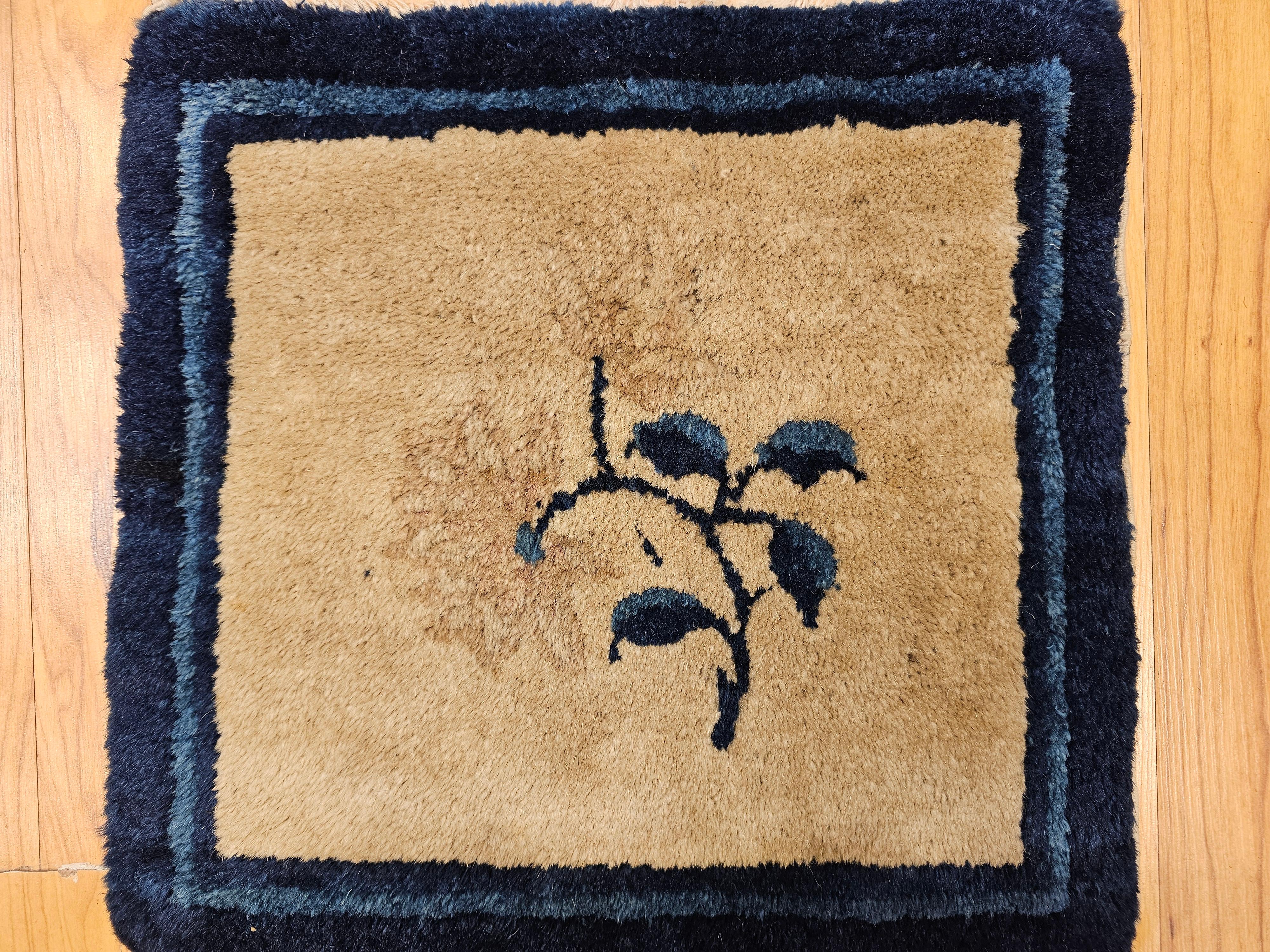 Beautiful hand-knotted small Chinese Art Deco rug.  The small square size Chinese rug has a single flower design in the center set on a tan color background with designs in plum, navy and blue.  The rug is beautifully framed with borders in navy and