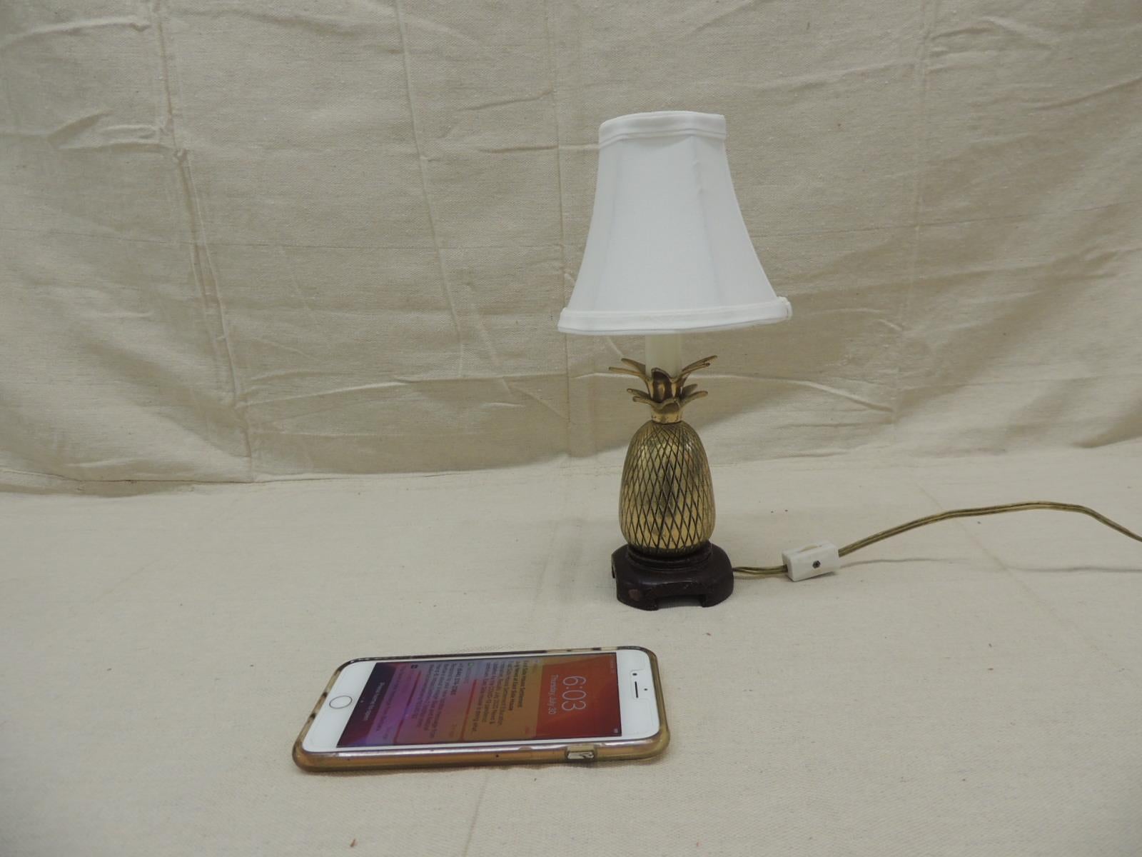 Vintage small brass pineapple decorative table lamp
with wooden base and white silk shade.
On/off cable switch and candelabra bulb.
Size: 11” H x 2.5