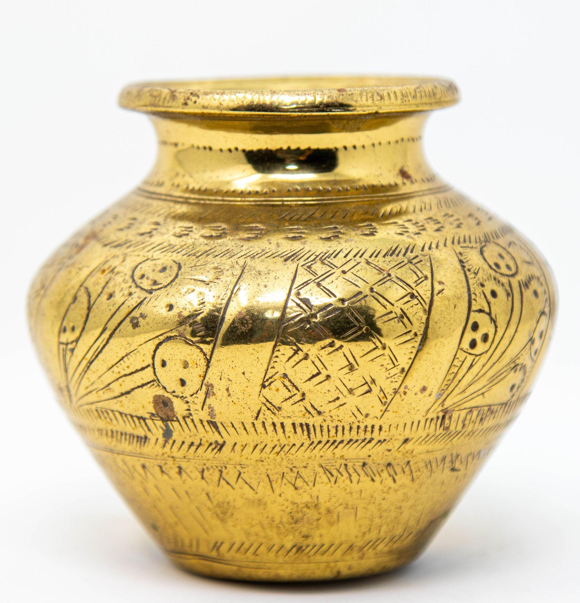 Add a touch of India's rich heritage to your home with this vintage small engraved brass lota from India, circa 1950s.
Hand-crafted from high-quality brass and adorned with intricate engravings, this antique vessel showcases traditional Indian
