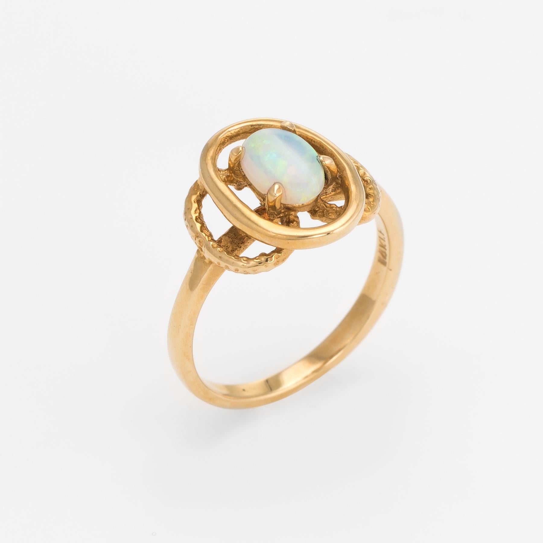 Finely detailed vintage opal cocktail ring (circa 1960s to 1970s), crafted in 14 karat yellow gold. 

Centrally mounted natural opal measures 7mm x 5mm (estimated at 0.75 carats). The opal is in excellent condition and free of cracks or chips. 

The