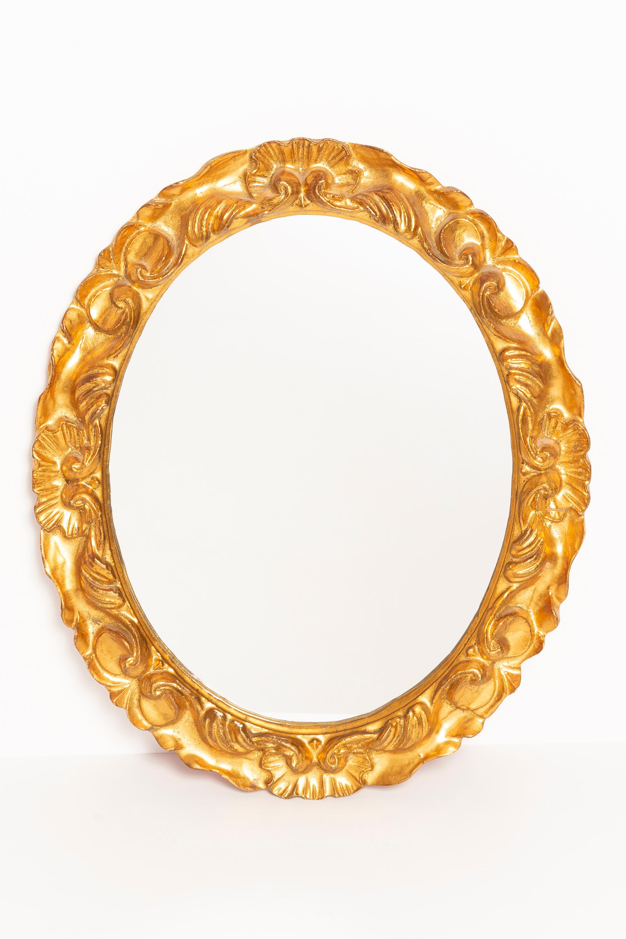 A beautiful oval mirror in a golden decorative frame with flowers from Italy. The frame is made of wood. Mirror is in very good vintage condition, no damage or cracks in the frame. Original glass. Beautiful piece for every interior! Red velvet on