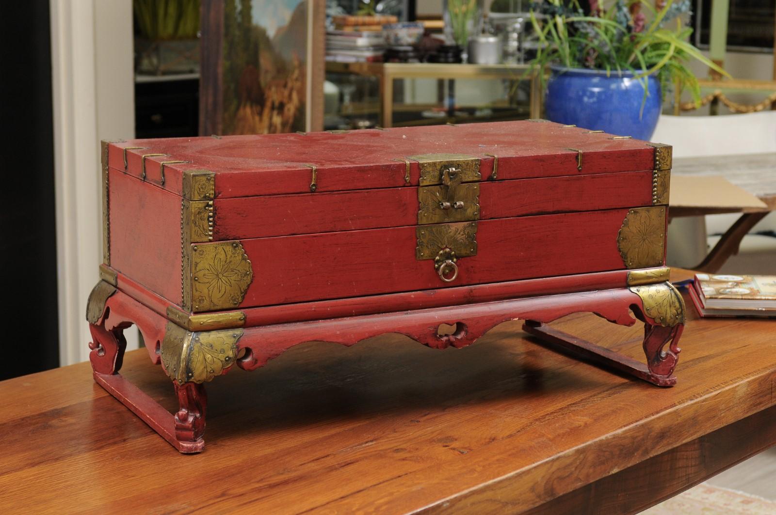 This Korean trunk is painted red with brass detail.
The top opens to a 2 inch shelf and there is a drawer at the bottom which is 3 inches deep.
The truck will bring a lovely decorative touch to any room.