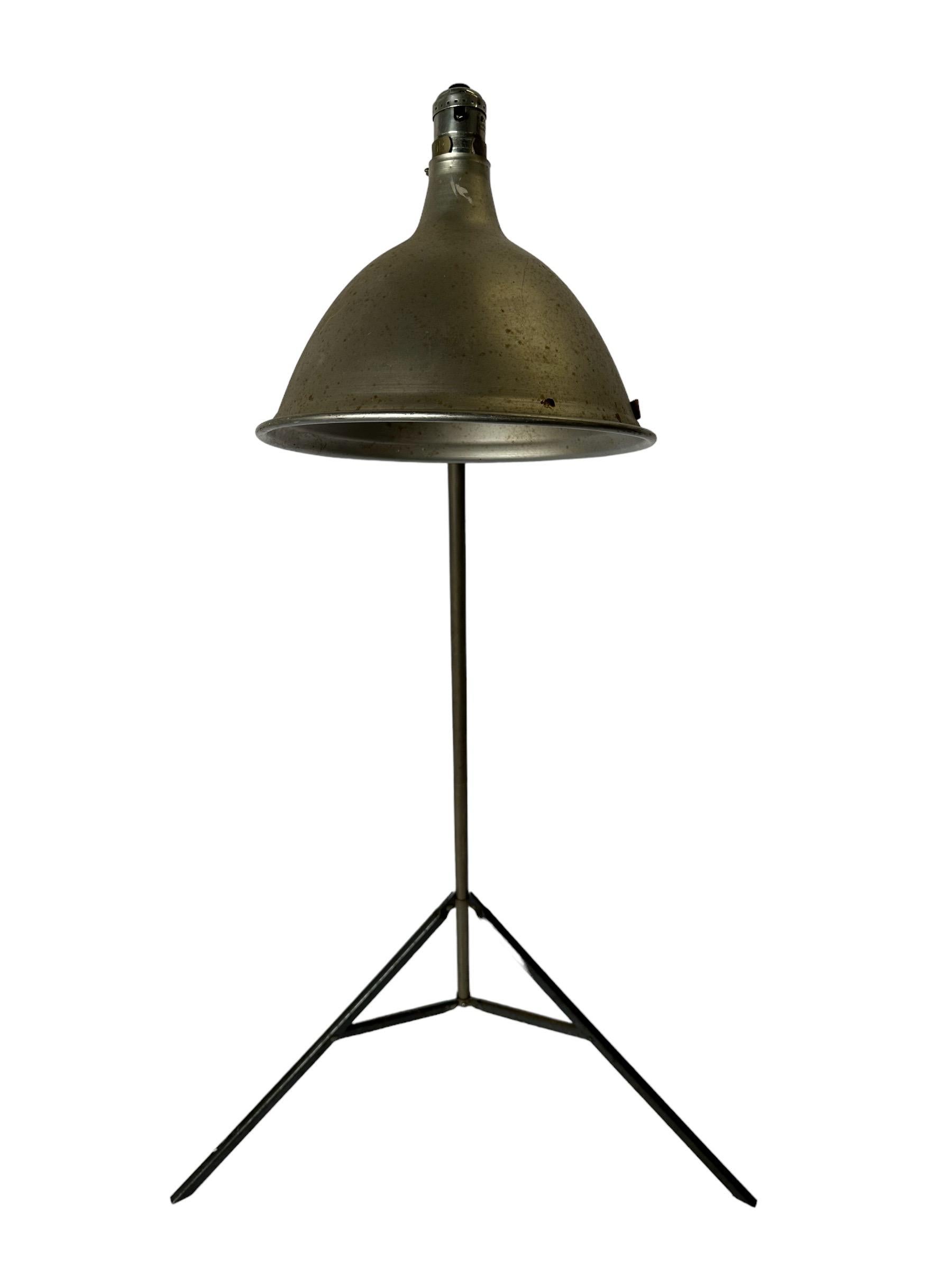 Industrial chic metal tripod floor lamp. Adjustable height and adjustable pivoting shade. Signed with Smith Victor manufacturer’s tag. Perfect for modern living with a nod to the past.