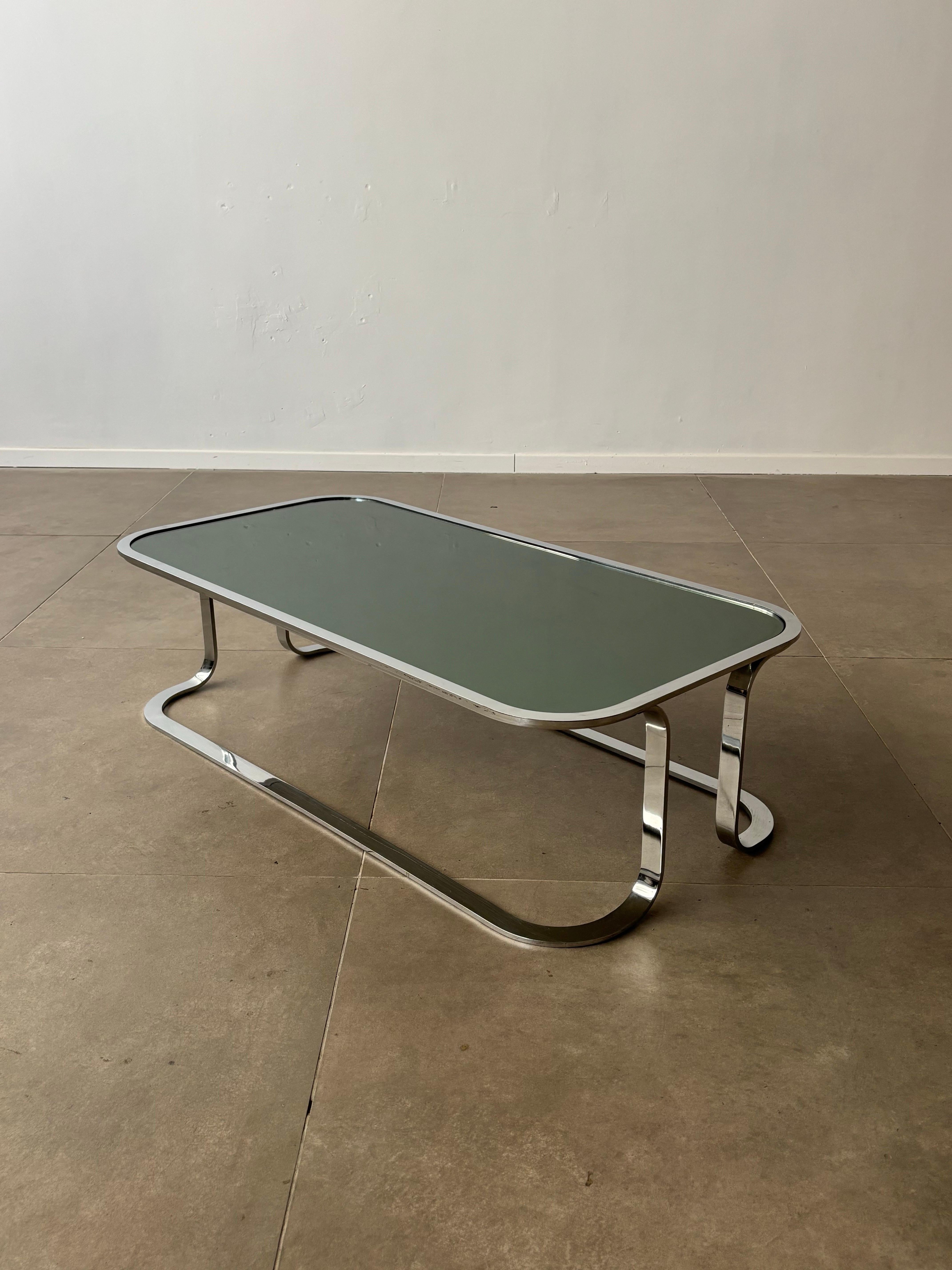Dieser italienische Vintage-Couchtisch aus den 1970er Jahren ist ein beeindruckendes Beispiel für das elegante und raffinierte Design dieser Zeit. Mit ihrer verspiegelten Rauchglasplatte strahlt sie eine raffinierte Eleganz aus, während sie ihre