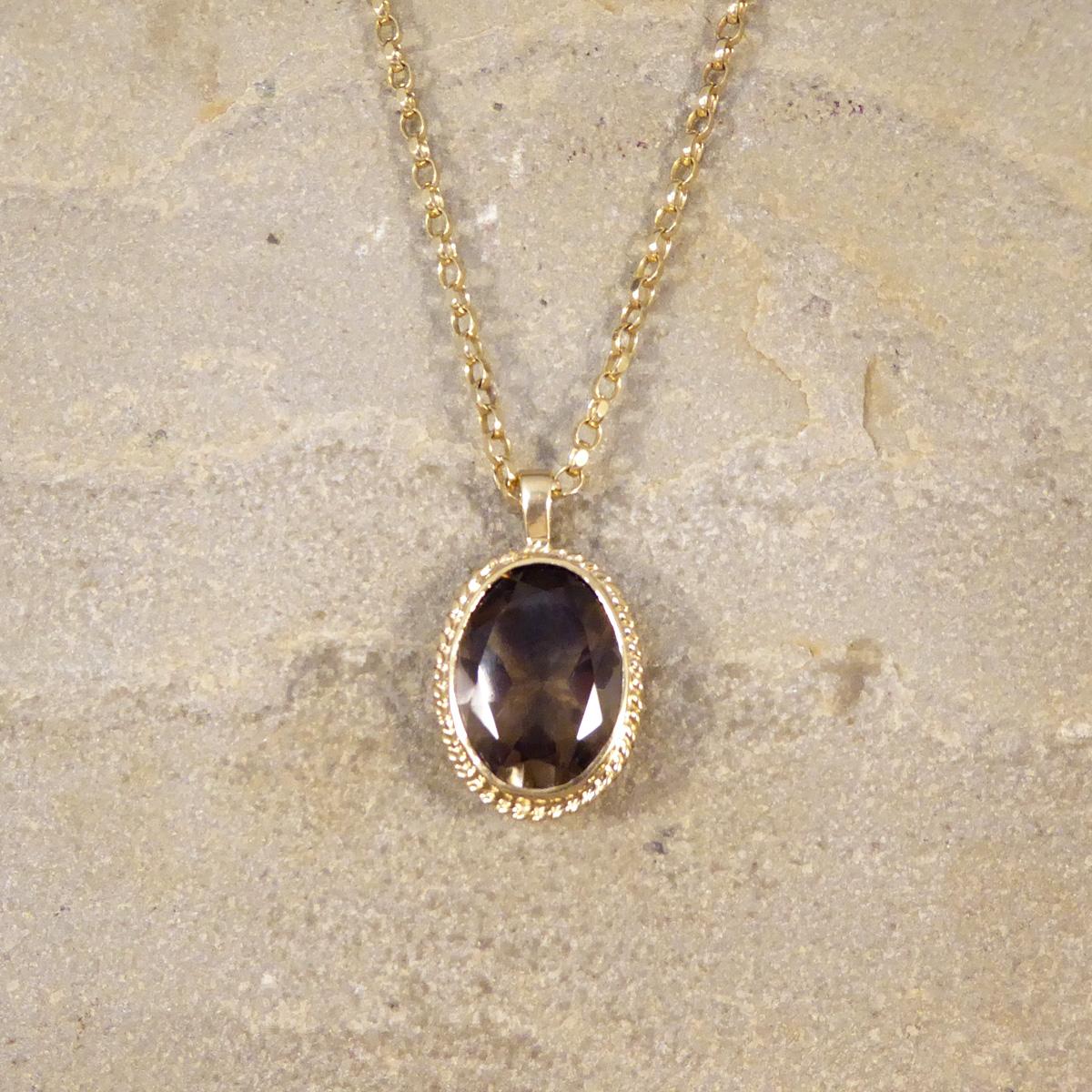 Diese Vintage-Halskette trägt einen verführerischen Rauchquarz-Anhänger in einer Fassung aus 9 Kt. Gelbgold mit einem seilähnlichen Heiligenschein, der ihr eine antike Ästhetik und Ausstrahlung verleiht. Der Anhänger ist vollständig gepunzt und