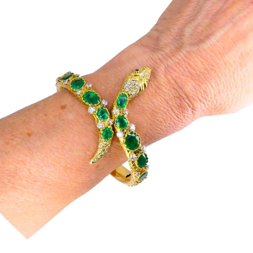 Una pulsera brazalete de serpiente vintage única, de oro de 18 quilates, con esmeralda y diamantes.
El cuerpo de la serpiente está engastado con una serie de esmeraldas ovaladas de talla facetada. Cada gema está engastada en un bisel festoneado que