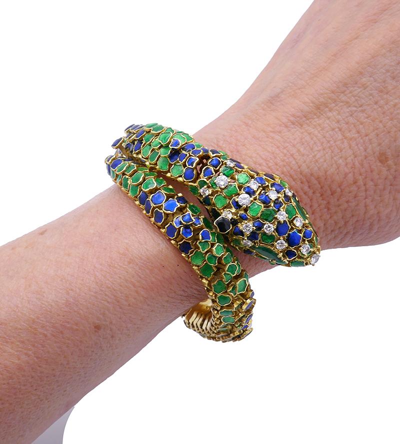 An extraordinary vintage snake bracelet, made of 18k yellow gold and enamel, featuring diamond and emerald.
The workmanship of the piece is outstanding. Each scale is hand-crafted. Being irregular in shape and size, the scales are placed on two