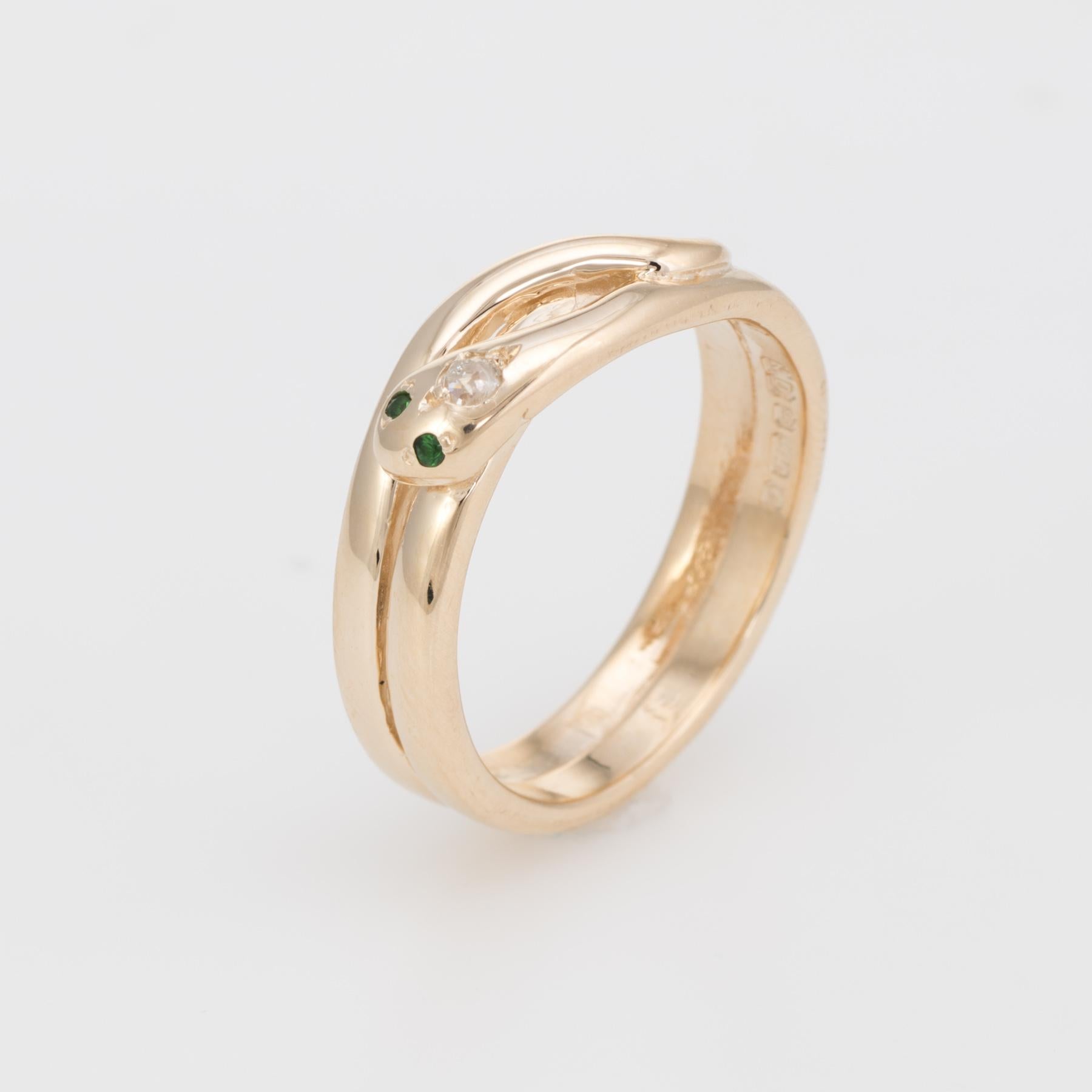 Finely detailed vintage snake ring, crafted in 18 karat yellow gold. 

One estimated 0.05 carat old mine cut diamond (estimated at I-J color and SI2 clarity), is accented with two estimated 0.02 carat emeralds (total estimated weight of 0.04