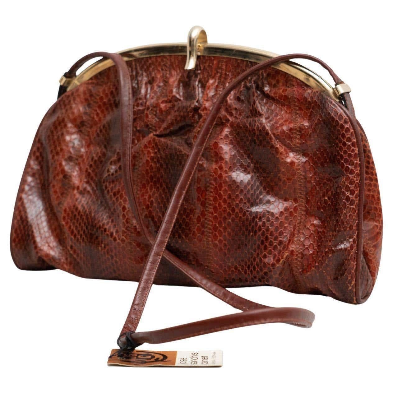 Vintage snakeskin leather bag in brown tones with a golden clasp. With an inside zipped pocket
Long and semi-rigid handle of the same leather. The interior has one compartment.

Manufactured in Spain circa 1950.

Materials:
Snakeskin.