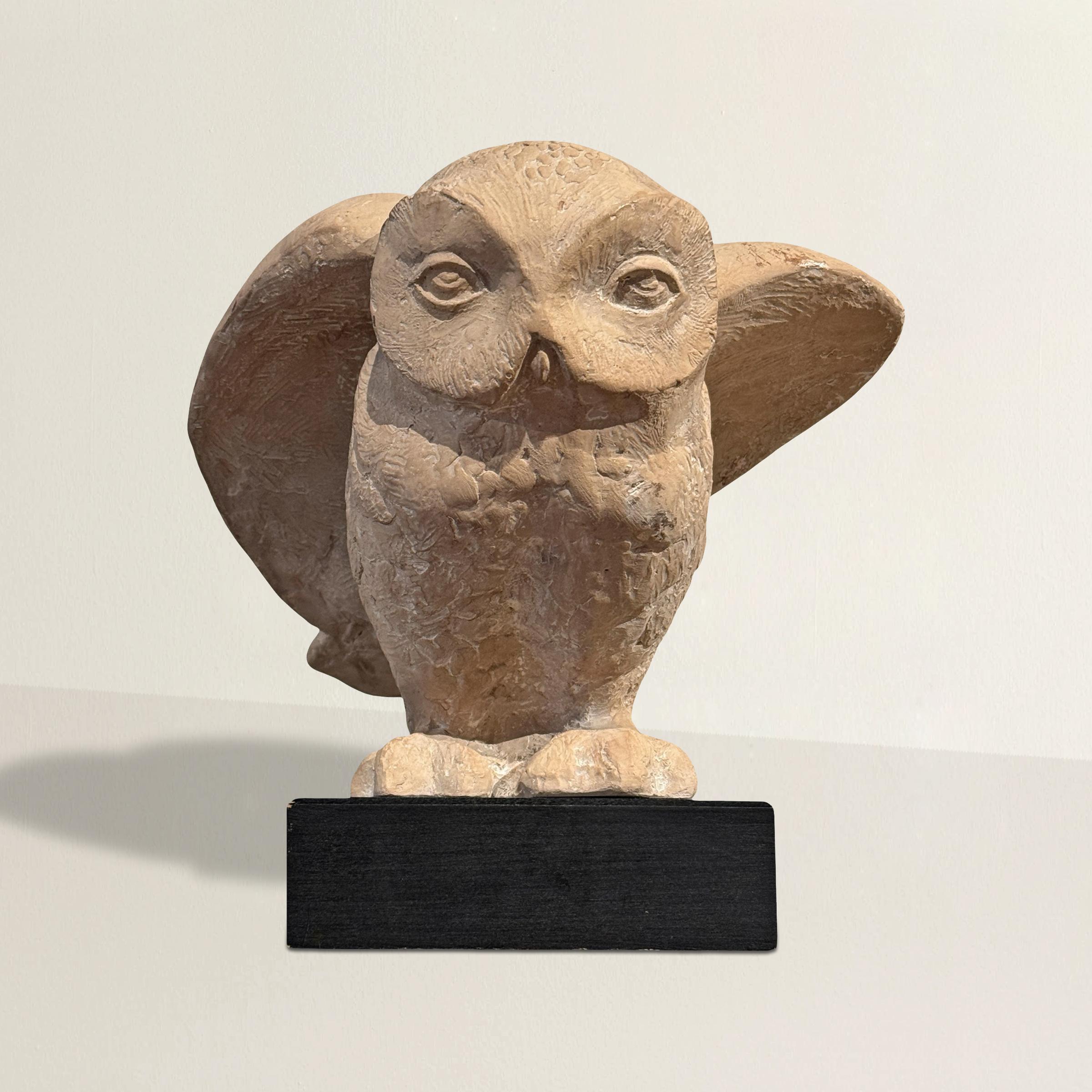 Questa drammatica scultura di gufo delle nevi di Klara Sever per Austin Productions, datata 1975, sembra un momento congelato a metà del movimento. Fuso in pietra composita e appollaiato su una base di legno, il gufo è colto a metà del suo volo: