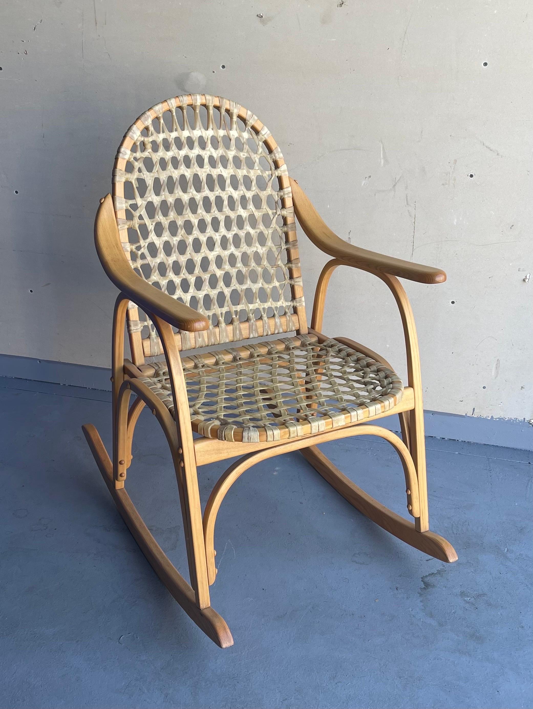 Vintage snowshoe cocking chair by Iverson Snowshoe Co. in Michigan's Upper Peninsula, circa 1980s. A unique ‘snowshoe’ rocking chair, with a bentwood ash frame with a woven lattice of rawhide strips to the seat and back. The rocker is very sturdy