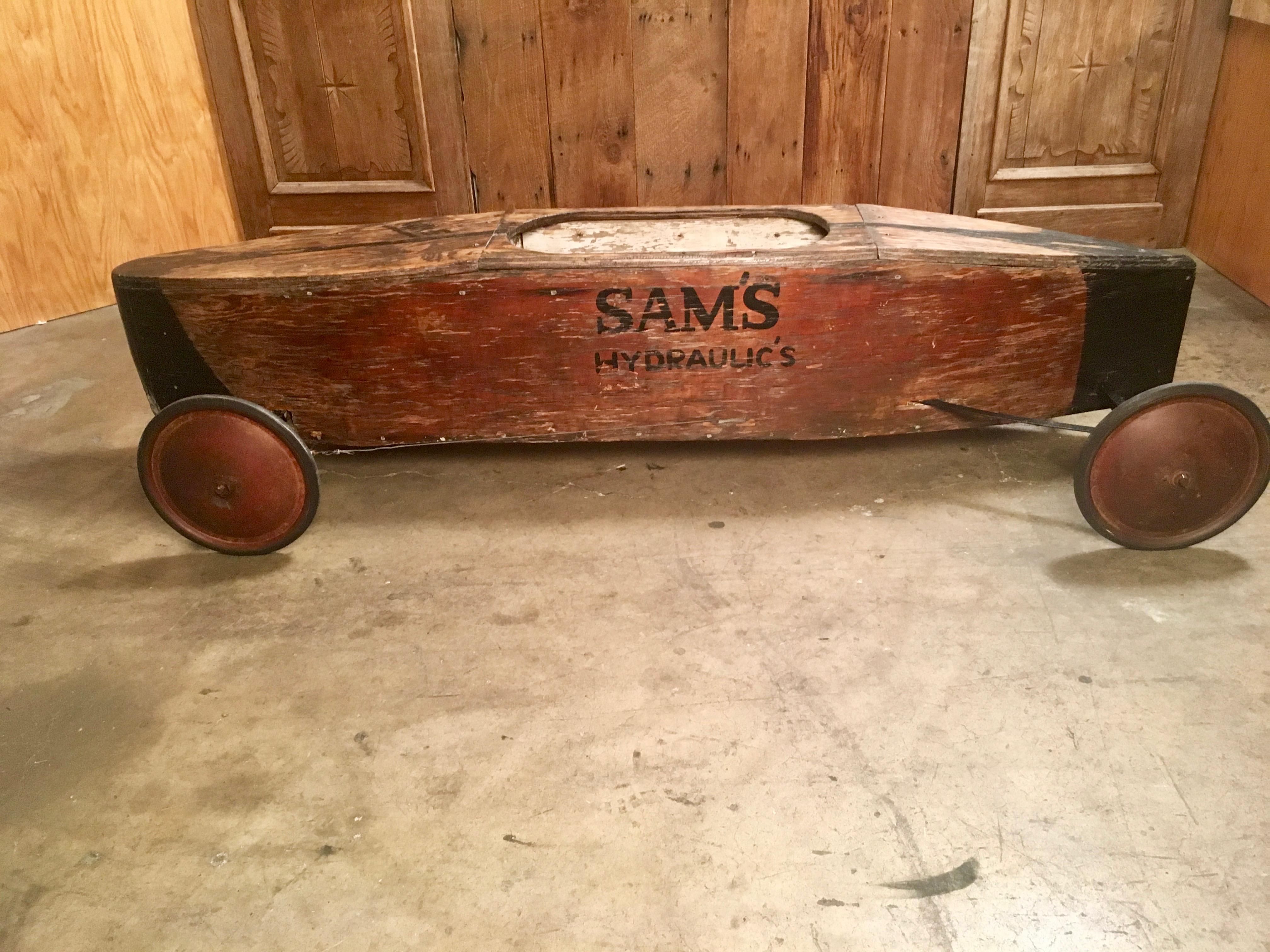 1940s handcrafted plywood soap box derby car with original advertising on the side and the drivers name on the top 