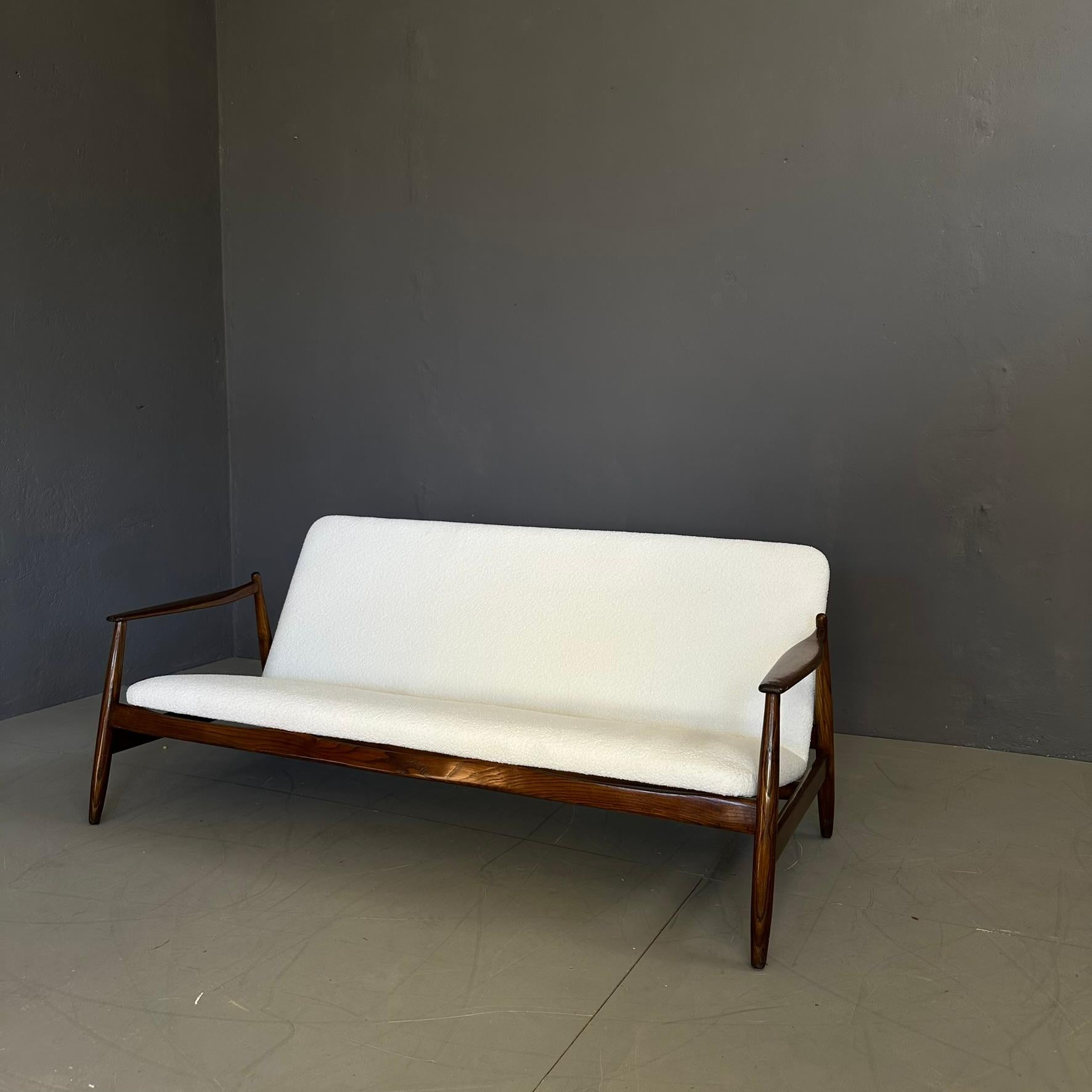 Canapé des années 60, fabrication italienne.
Le canapé a une structure simple en bois de teck brun clair, qui rappelle le style danois.
Rembourrage en tissu bouclé blanc.
Étiquette de production Pizzetti, visible sur les photos.